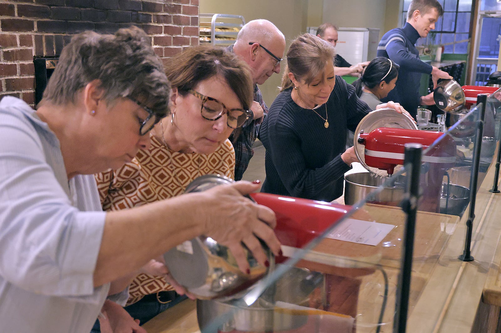 Students in the cooking class, (from left to right) Kim Organ and Cindy Woodruff, Jeff and Jackie Miller, and Meetal and Geoffrey Reed, at Le Torte Dolci Bakery learn how to make pizza crurst from scratch Friday, Jan. 31, 2025. BILL LACKEY/STAFF