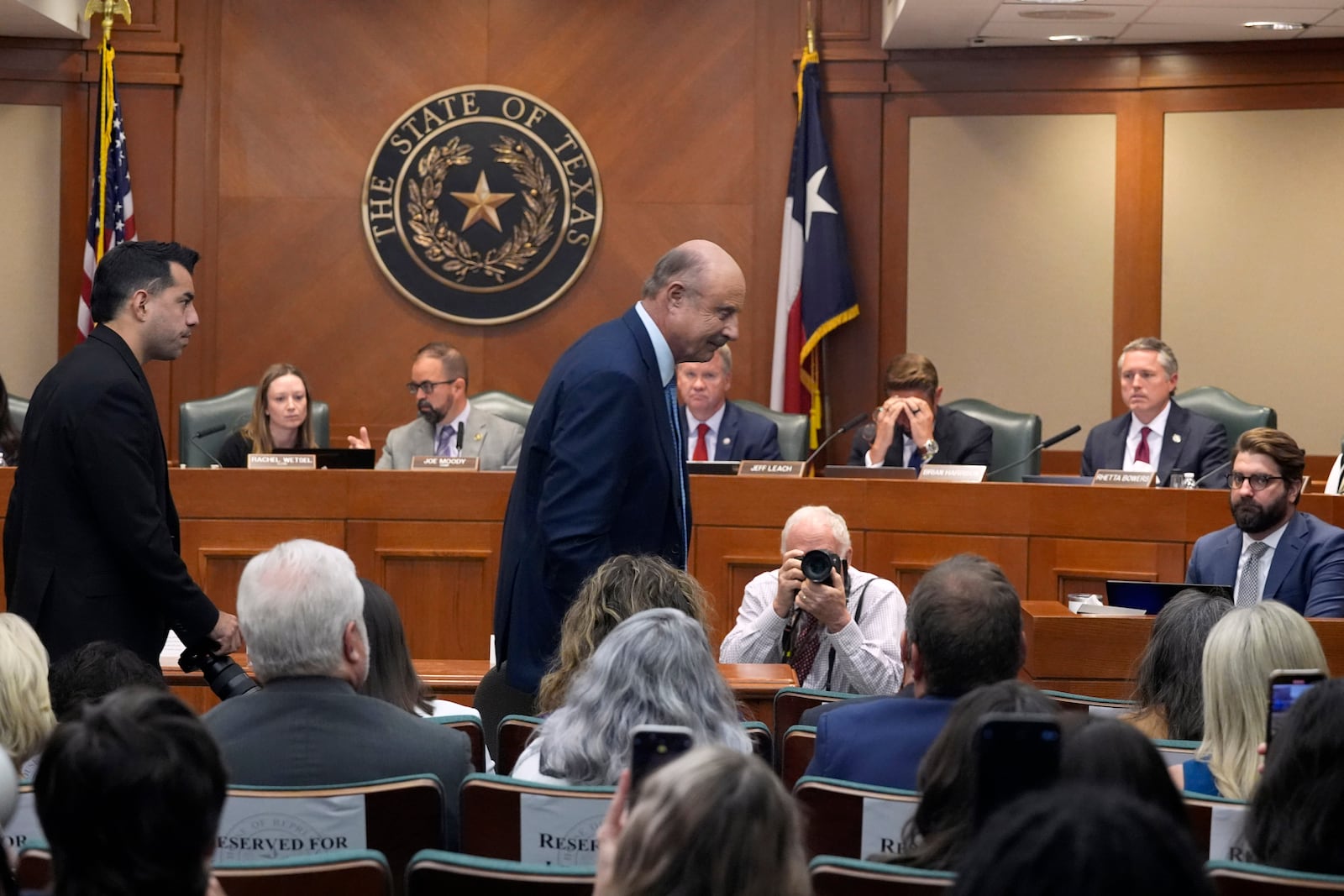 Dr. Phil McGraw, in blue suit, leaves the room after giving testimony to a committee discussing the case of death row inmate Robert Roberson, Monday, Oct. 21, 2024, in Austin, Texas. (AP Photo/Tony Gutierrez)