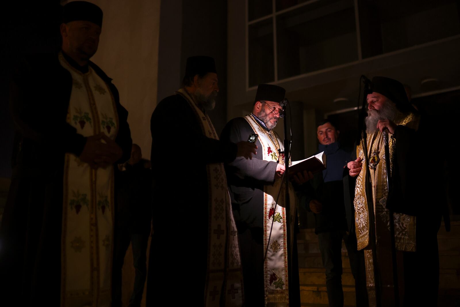 Priests read prayers during a vigil in the town of Kocani, North Macedonia, Tuesday, March 18, 2025 following a massive fire in a nightclub early Sunday. (AP Photo/Armin Durgut)