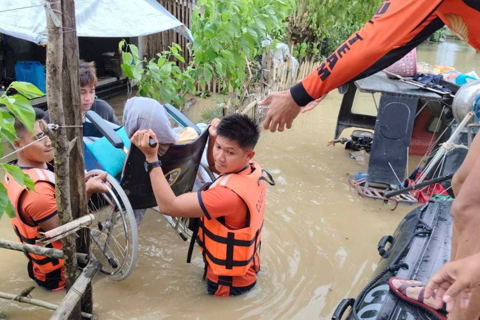 In this handout photo provided by the Philippine Coast Guard, rescuers carry a resident trapped in their homes after floods caused by Tropical Storm Trami, locally named Kristine, hit their village at Libon, Albay province, Philippines on Wednesday Oct. 23, 2024. (Philippine Coast Guard via AP)