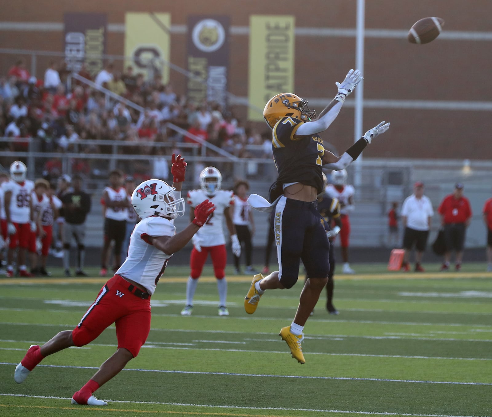 Springfield's Anthony Brown goes up for a first down catch as Wayne's Joshua Williams covers him during Friday's game. BILL LACKEY/STAFF