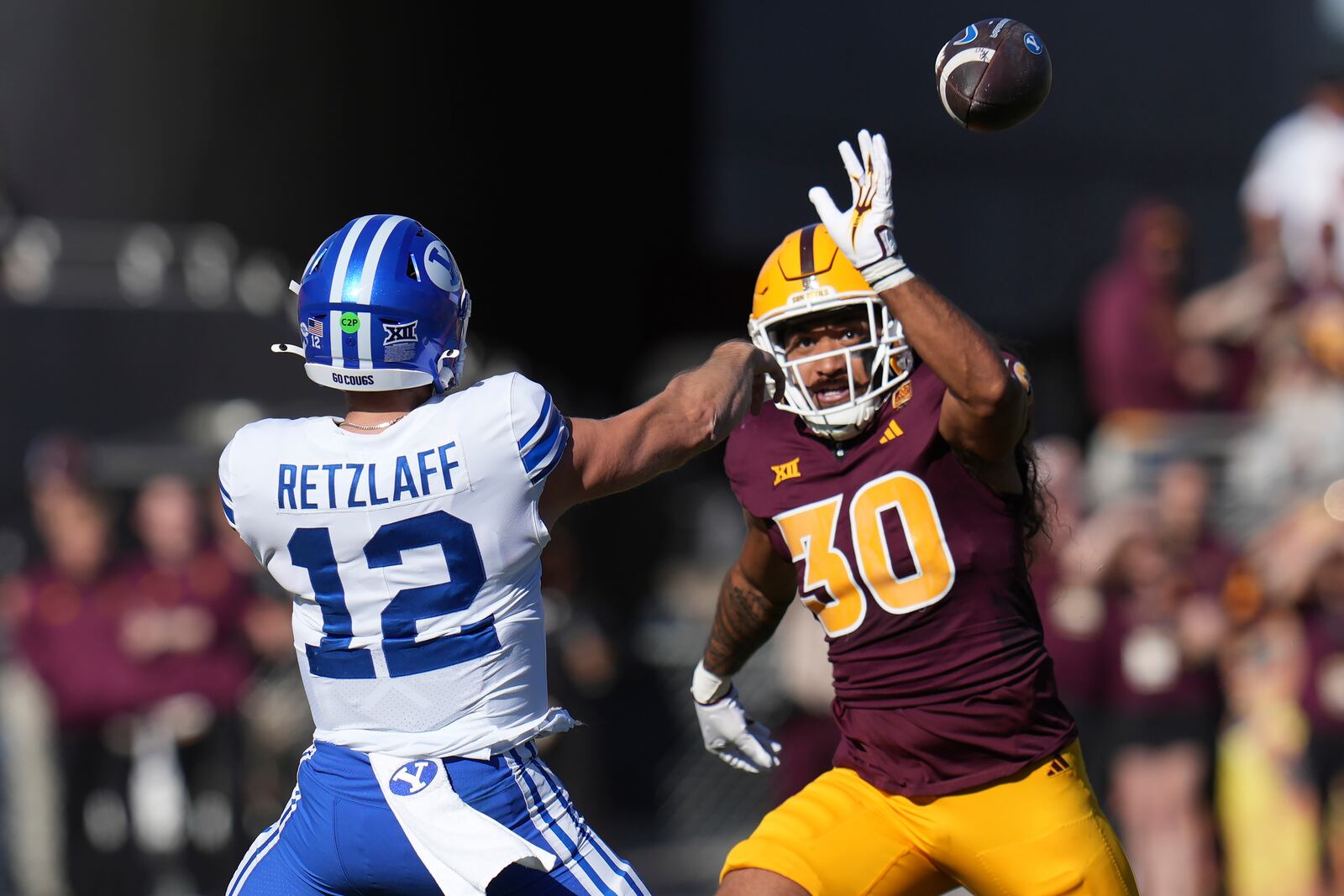 Brigham Young quarterback Jake Retzlaff (12) gets off a pass against Arizona State linebacker Zyrus Fiaseu (30) during the first half of an NCAA college football game Saturday, Nov. 23, 2024, in Tempe, Ariz. (AP Photo/Ross D. Franklin)