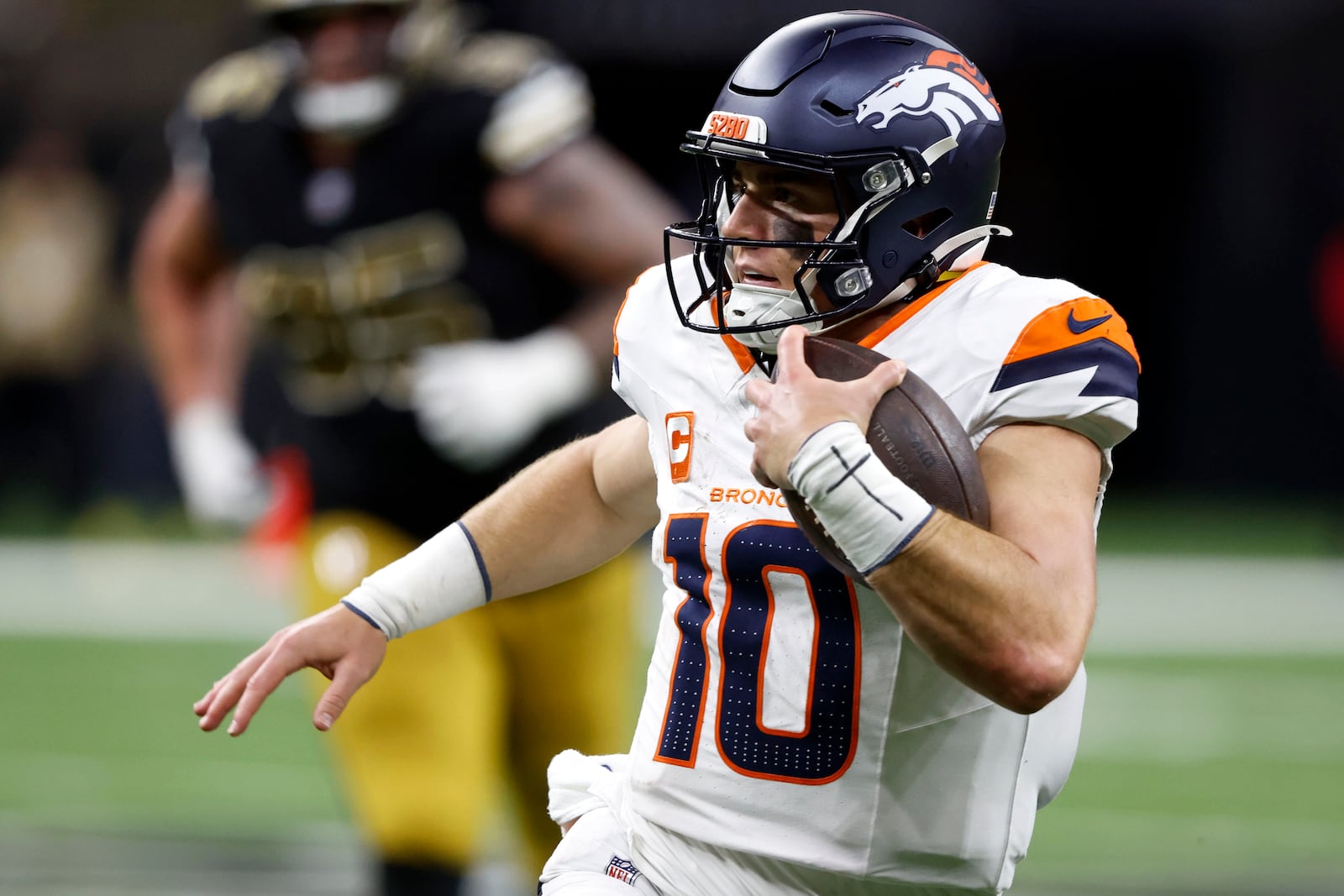 Denver Broncos quarterback Bo Nix scrambles up field during the second half of an NFL football game against the New Orleans Saints, Thursday, Oct. 17, 2024, in New Orleans. (AP Photo/Butch Dill)