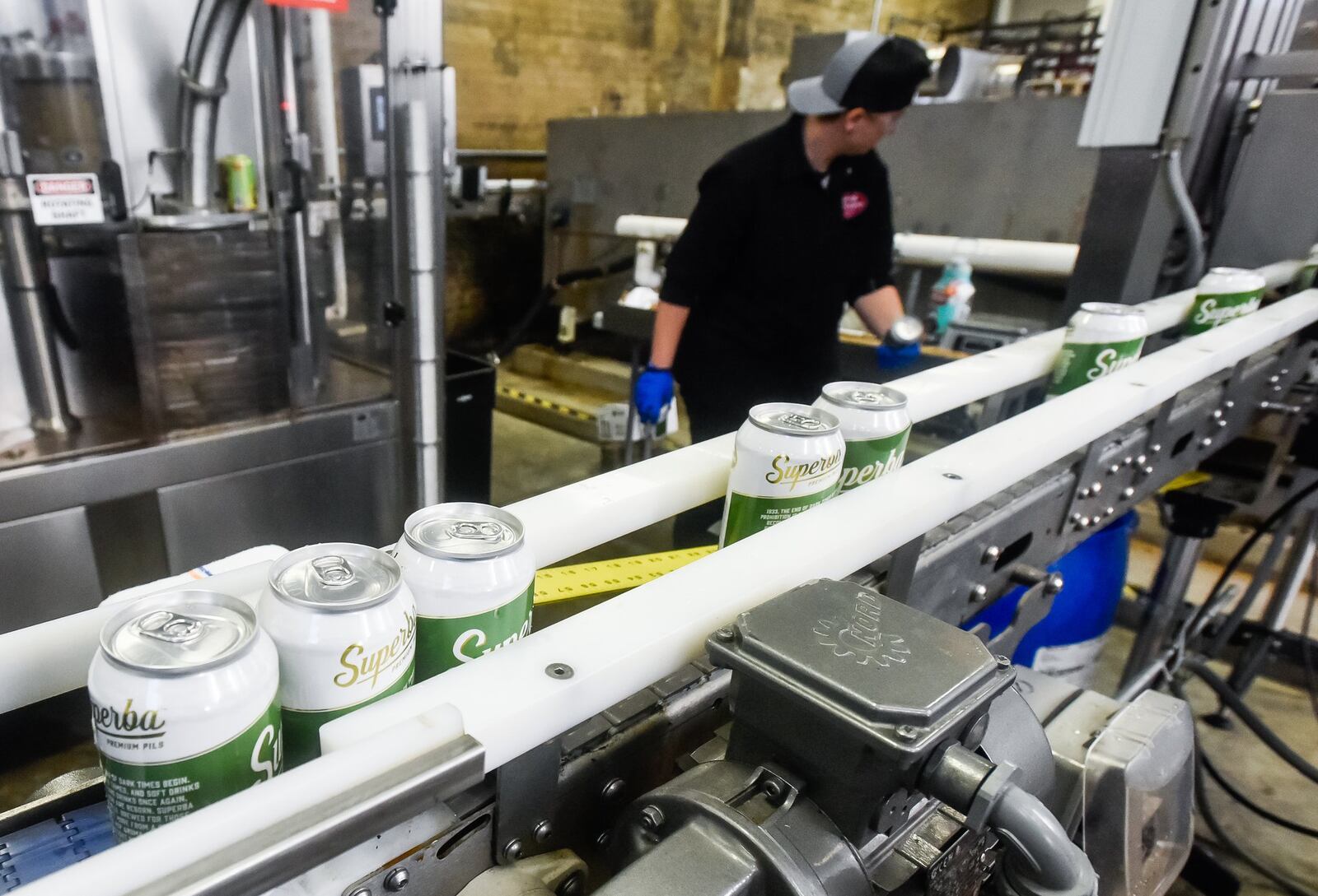 Employees can a batch of Superba beer at Warped Wing Brewing Company Thursday, Dec. 19, 2019 on Wyandot Street in Dayton. NICK GRAHAM/STAFF