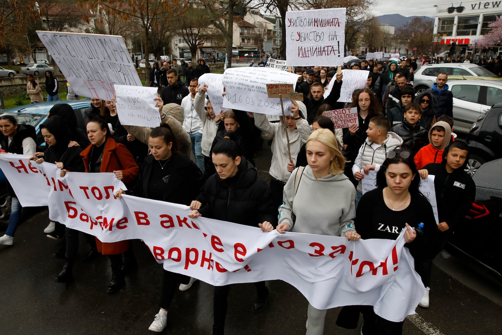 Protesters hold placards as they march during protest following a massive nightclub fire in the town of Kocani, North Macedonia, Monday, March 17, 2025. (AP Photo/Boris Grdanoski)