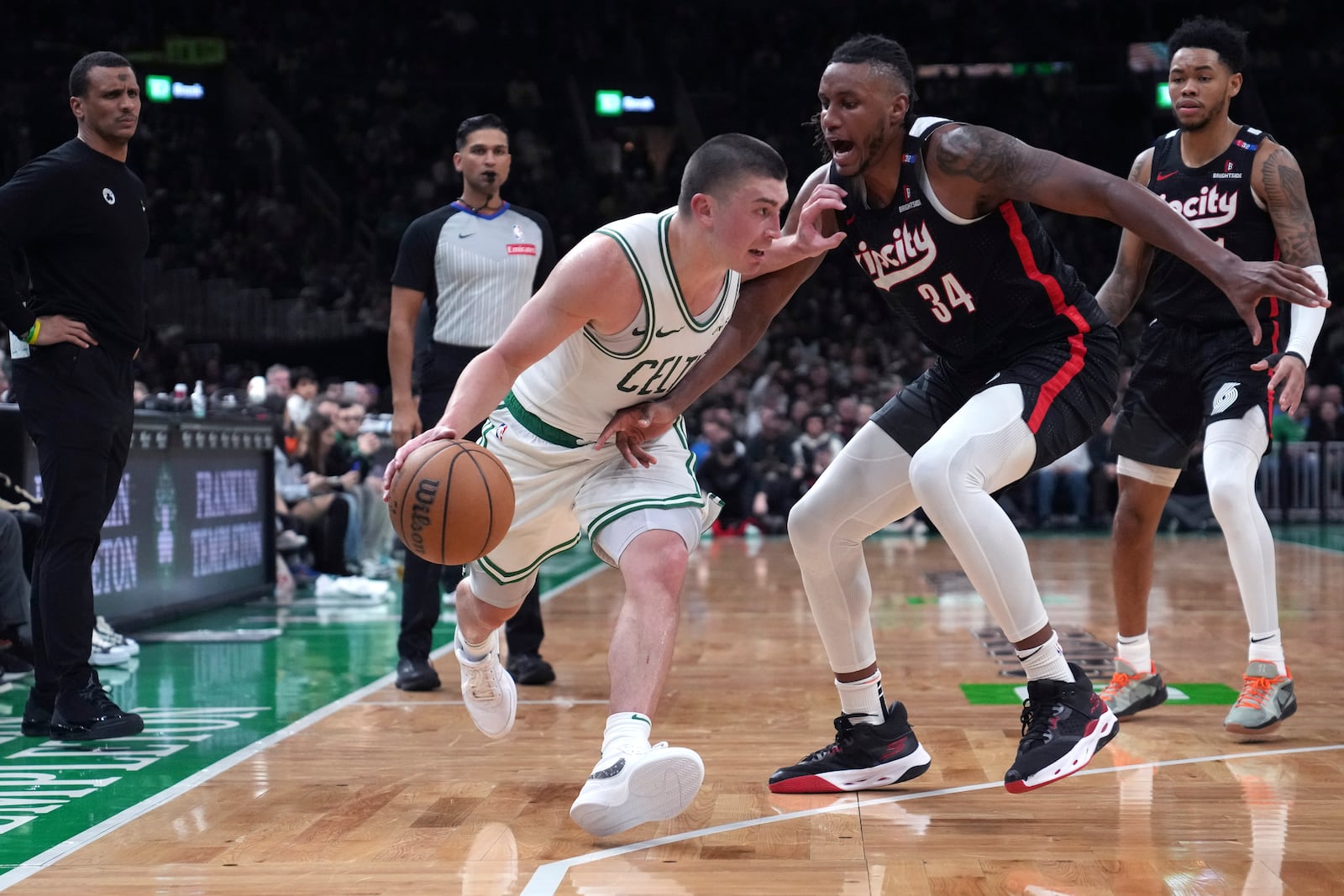 Boston Celtics guard Payton Pritchard, left, drives to the basket against Portland Trail Blazers forward Jabari Walker (34) during the second half of an NBA basketball game, Wednesday, March 5, 2025, in Boston. (AP Photo/Charles Krupa)