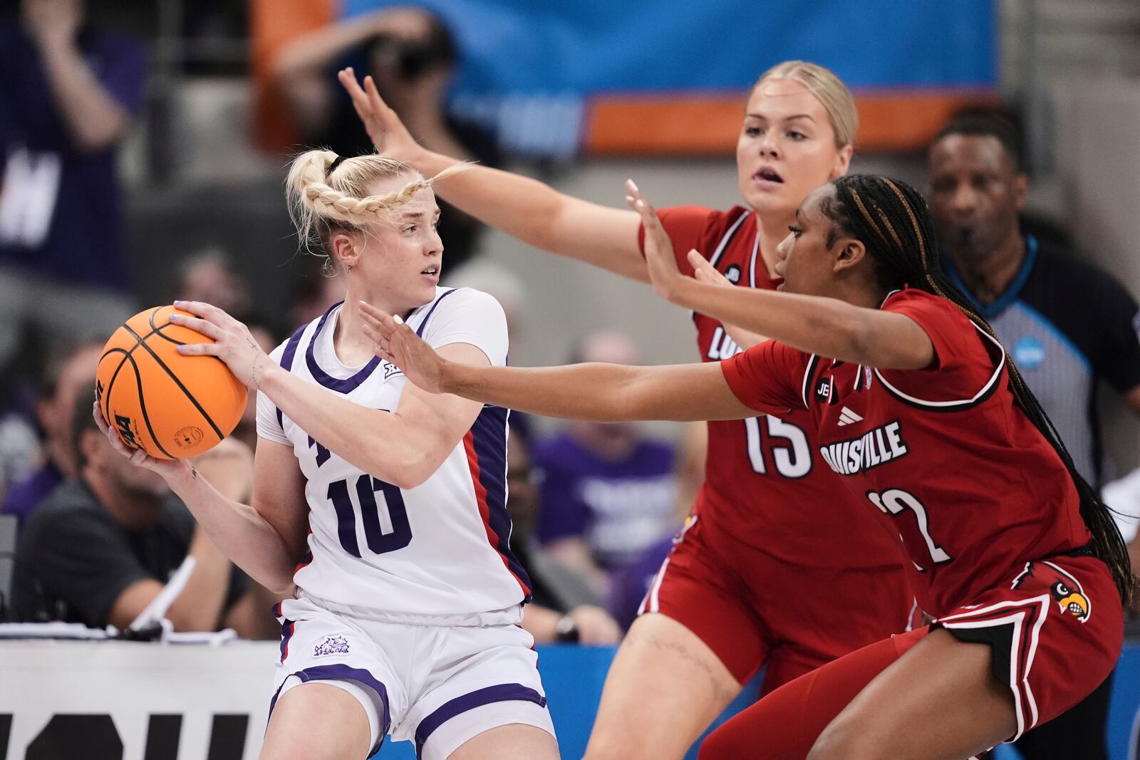 TCU guard Hailey Van Lith (10) attempts to make a pass as Louisville's Isla Juffermans (15) and Tajianna Roberts, right, defend in the first half in the second round of the NCAA college basketball tournament in Fort Worth, Texas, Sunday, March 23, 2025. (AP Photo/Tony Gutierrez)