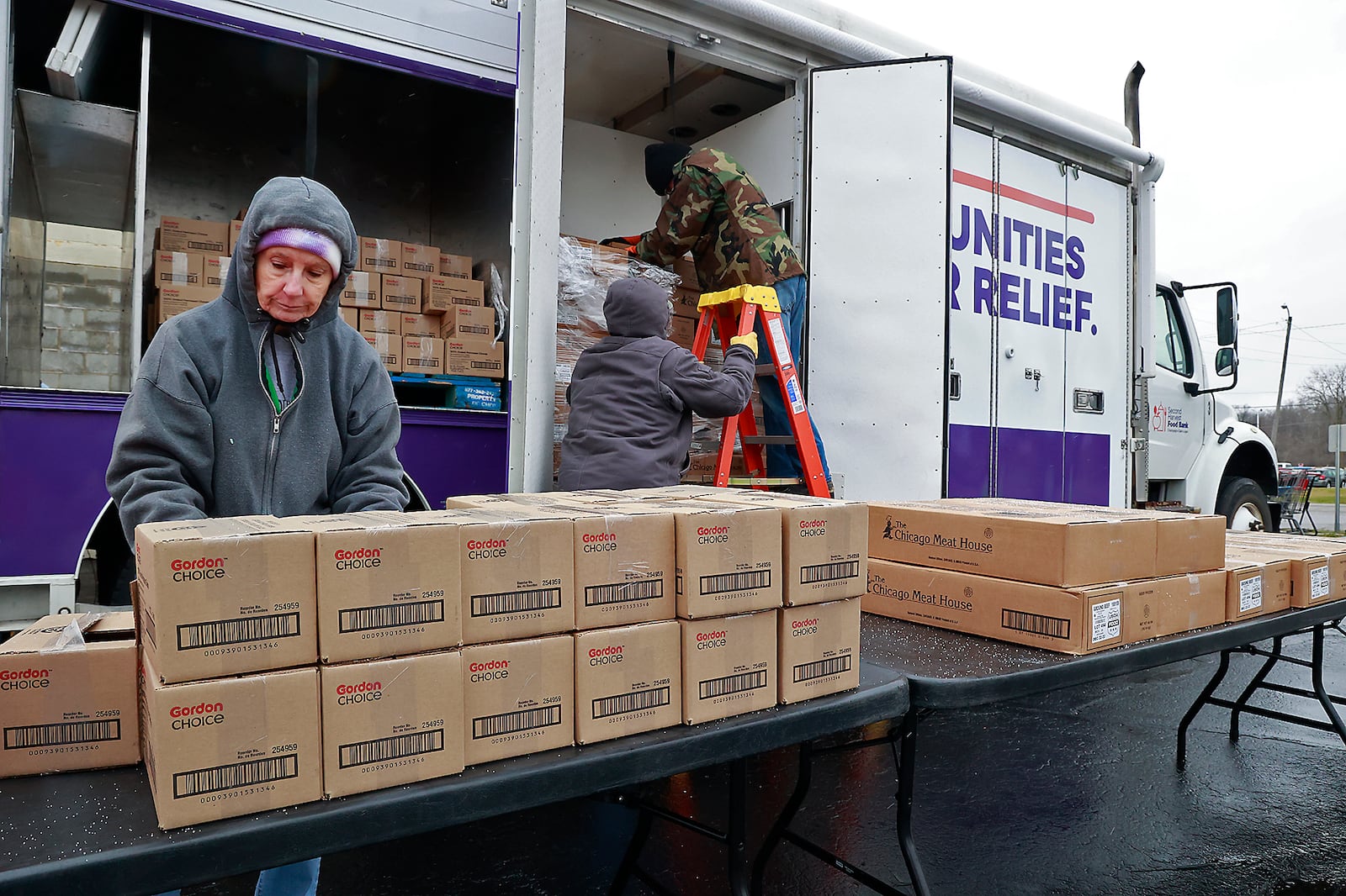 Volunteers at Second Harvest Food Bank prepare for a food distribution in the food bank parking lot Friday, Jan. 13, 2023. BILL LACKEY/STAFF