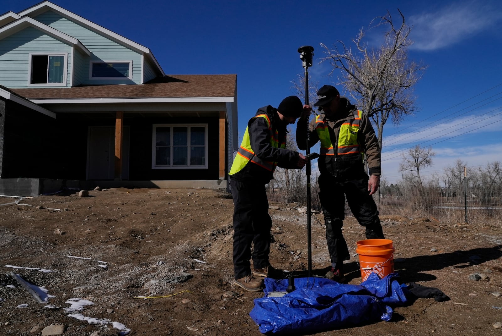 Technicians install a new water meter with a remote shutoff valve Thursday, Feb. 13, 2025, in Louisville, Colo. (AP Photo/Brittany Peterson)