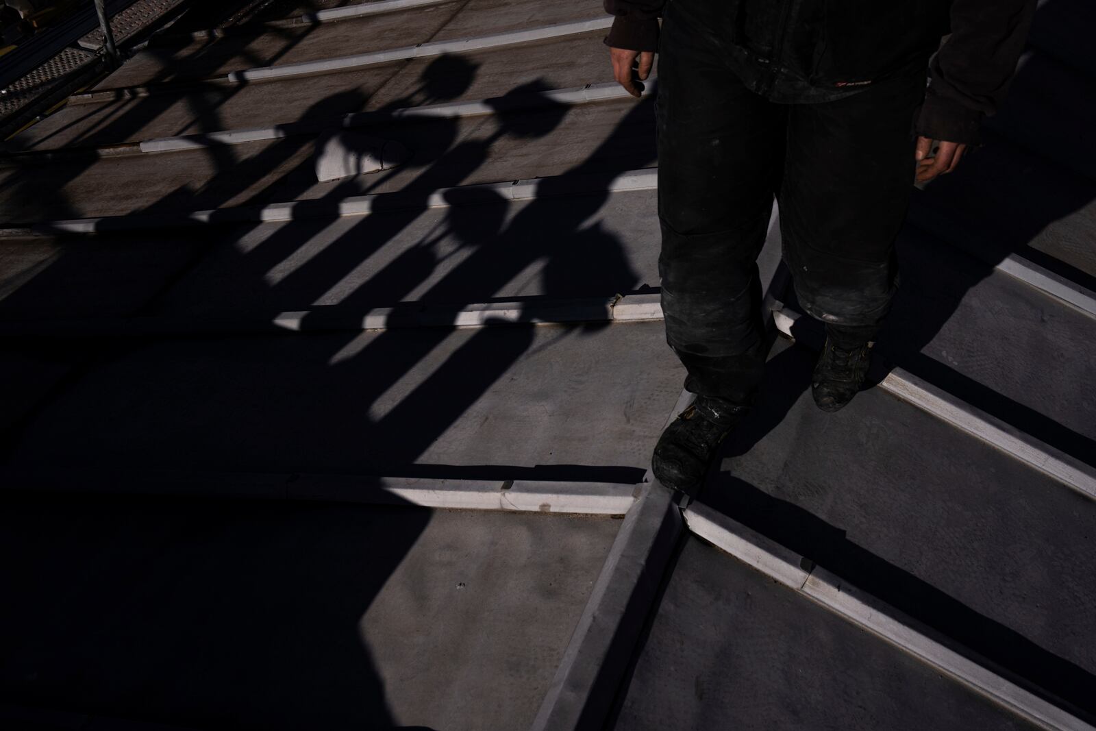 A roofer walks on a building in Paris, Wednesday, Nov. 20, 2024. (AP Photo/Louise Delmotte)