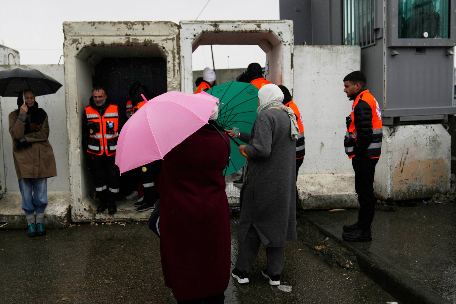 Palestinians brave the rain while they cross from the Israeli military Qalandia checkpoint near the West Bank city of Ramallah to Jerusalem, to participate in the Friday prayers at the Al-Aqsa Mosque compound during the Muslim holy month of Ramadan on Friday, March 7, 2025. (AP Photo/Nasser Nasser)