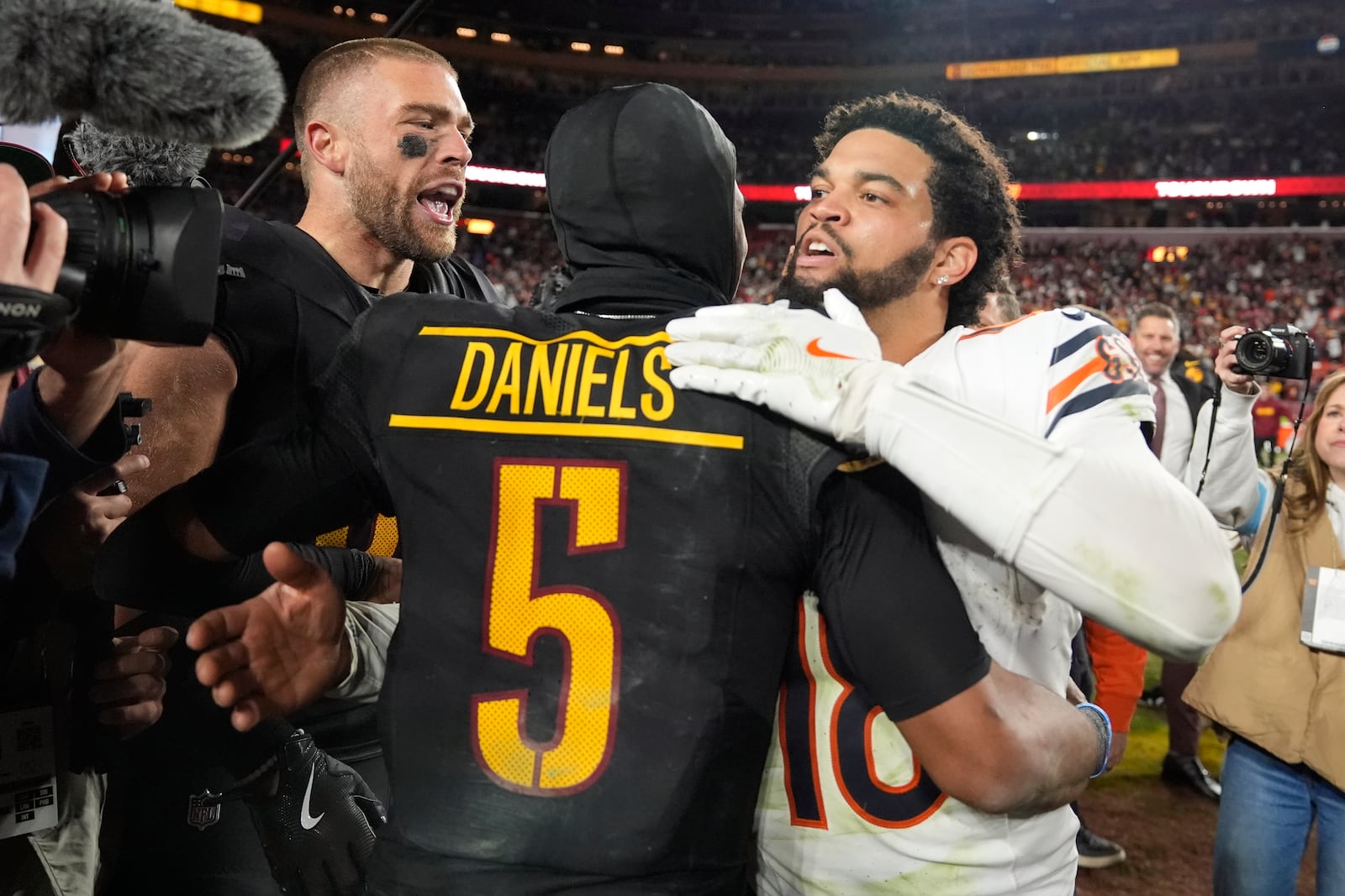 Washington Commanders quarterback Jayden Daniels (5) is congratulated by Chicago Bears quarterback Caleb Williams (18) after the Commanders won 18-15 in an NFL football game Sunday, Oct. 27, 2024, in Landover, Md. (AP Photo/Stephanie Scarbrough)