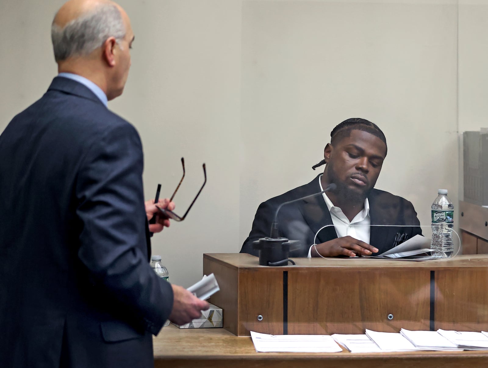 New England Patriots safety Jabrill Peppers looks over photographic evidence as he testifies in his assault and battery trial trial under cross examination from his attorney Marc Brofsky, left, Friday, Jan. 23, 2025, in Quincy, Mass. (David L. Ryan/The Boston Globe via AP, Pool)