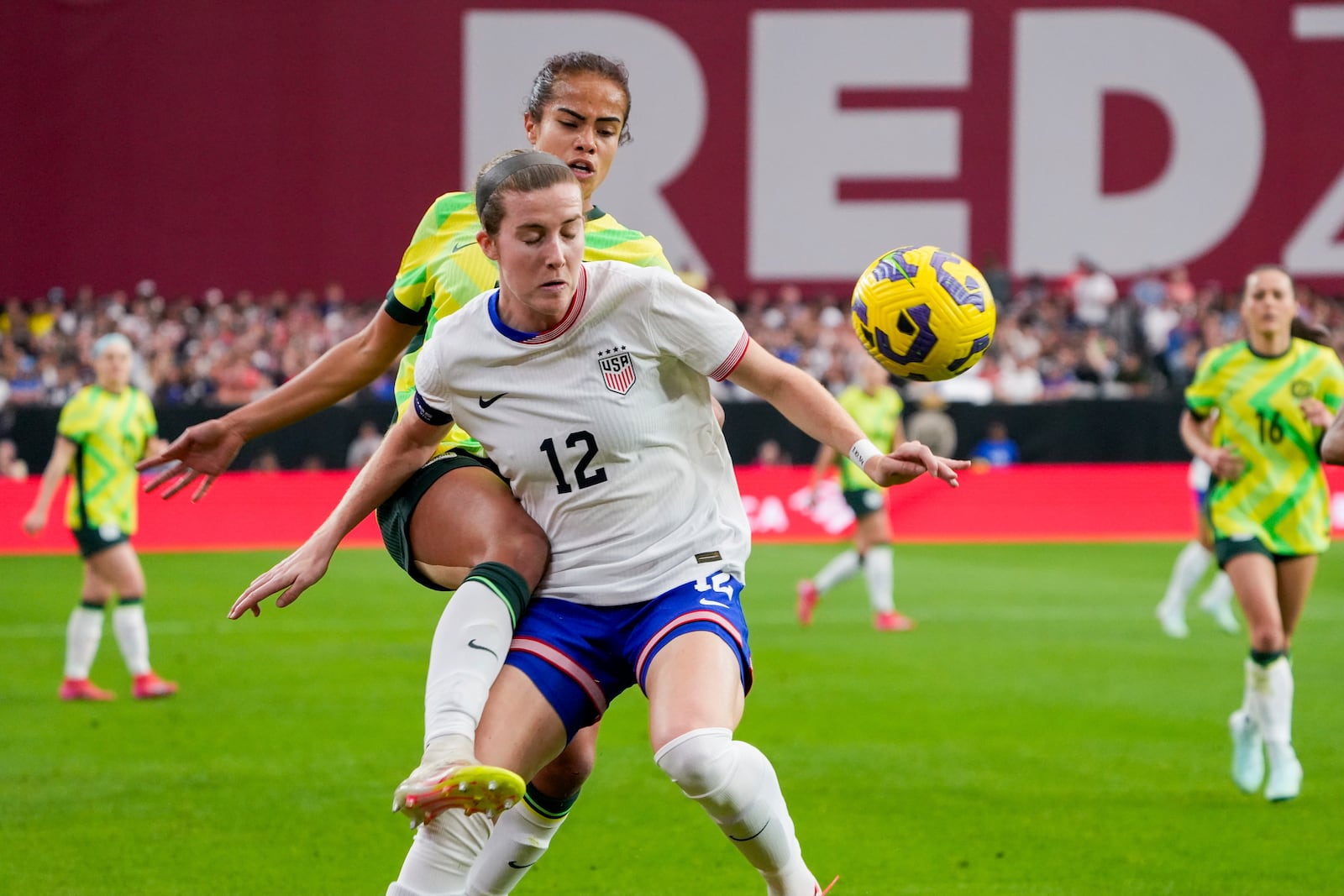 United States defender Tierna Davidson (12) and Australia forward Mary Fowler, center top, battle for the ball during the first half of a group stage match in the SheBelieves Cup women's soccer tournament, Sunday, Feb. 23, 2025, in Glendale, Ariz. (AP Photo/Samantha Chow)