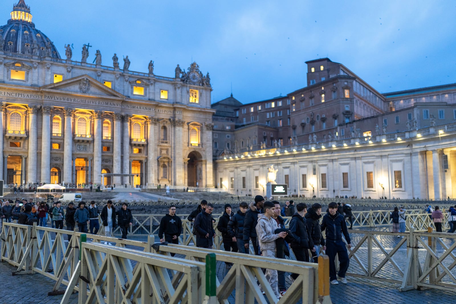 People walk in St. Peter's square at The Vatican, Monday, Feb. 24, 2025. (AP Photo/Mosa'ab Elshamy)