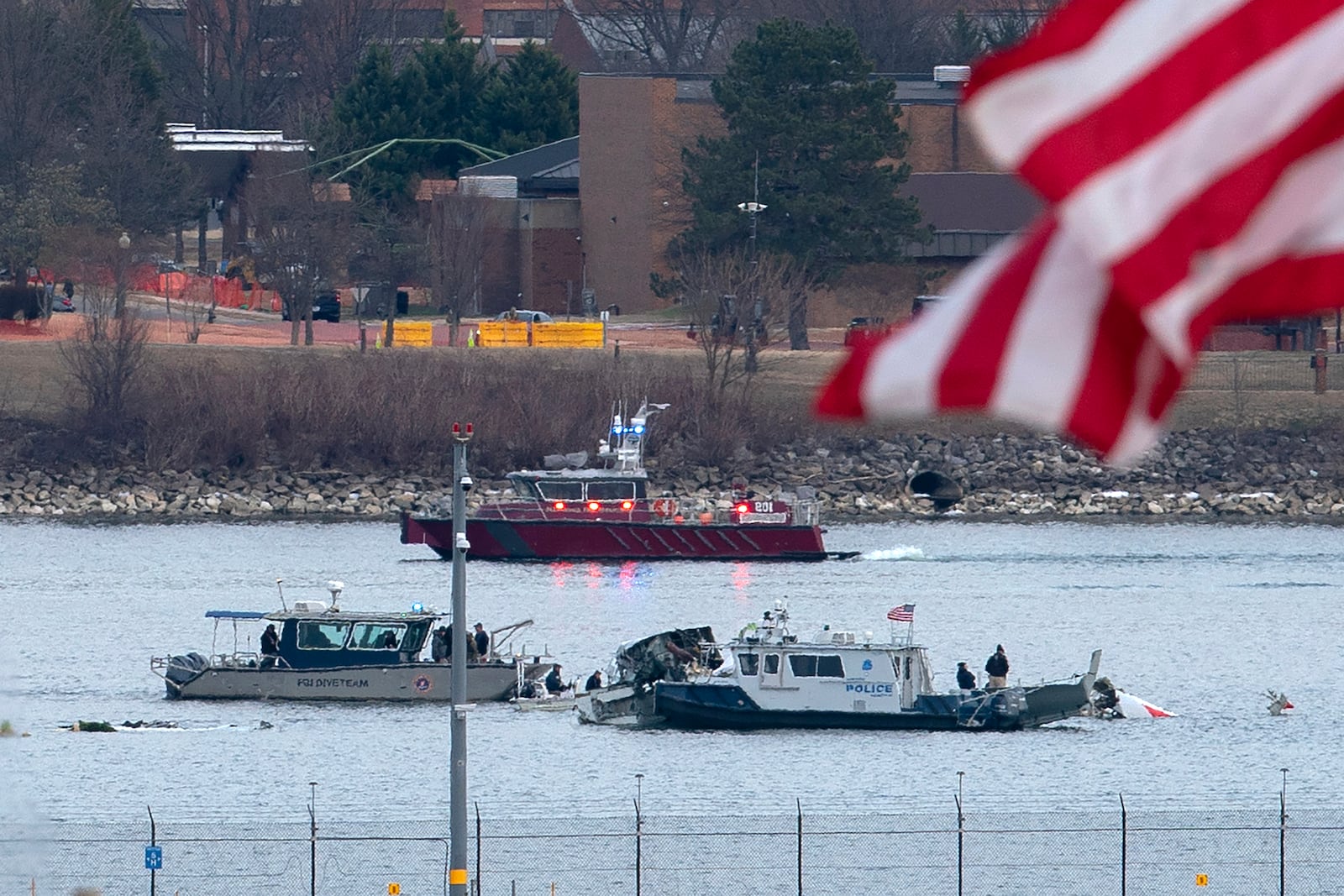 A diving team and police boat is seen around a wreckage site in the Potomac River from Ronald Reagan Washington National Airport, Thursday, Jan. 30, 2025, in Arlington, Va. (AP Photo/Jose Luis Magana)