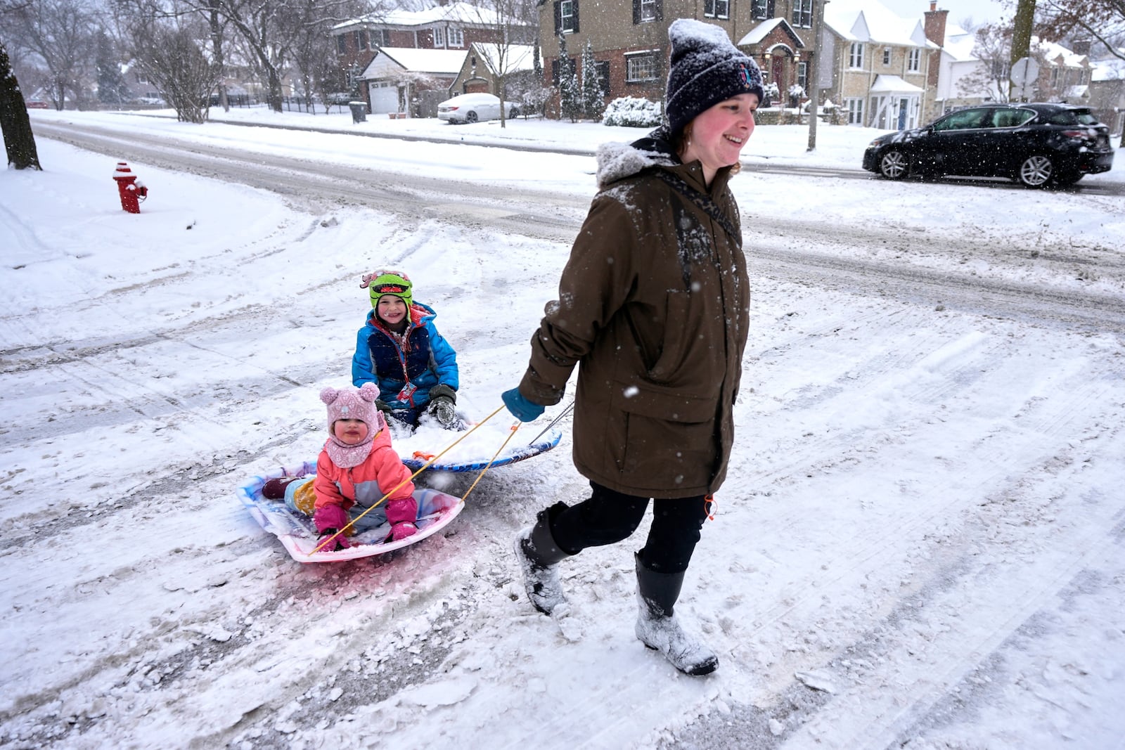 FILE - Natalie Burke pulls some kids on a sled during a snowfall, Feb. 12, 2025, in Shorewood, Wis. (AP Photo/Morry Gash, File)