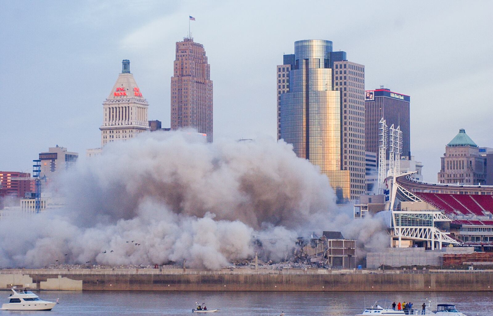 GREG LYNCH/JOURNALNEWS
A cloud of dust rises from where Cinergy Field once stood as seen from the Newport riverfront, Sunday morning.