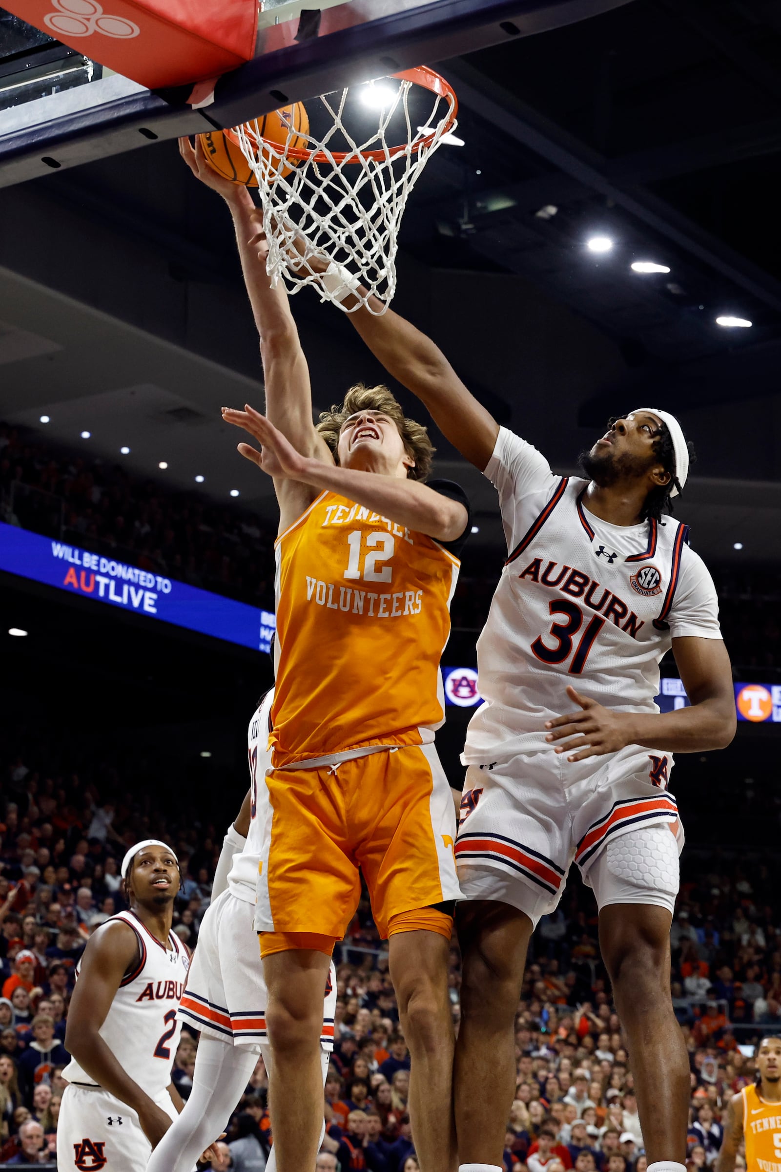 Tennessee forward Cade Phillips (12) is fouled by Auburn forward Chaney Johnson (31) as he goes up for a layup during the first half of an NCAA college basketball game, Saturday, Jan. 25, 2025, in Auburn. (AP Photo/Butch Dill)