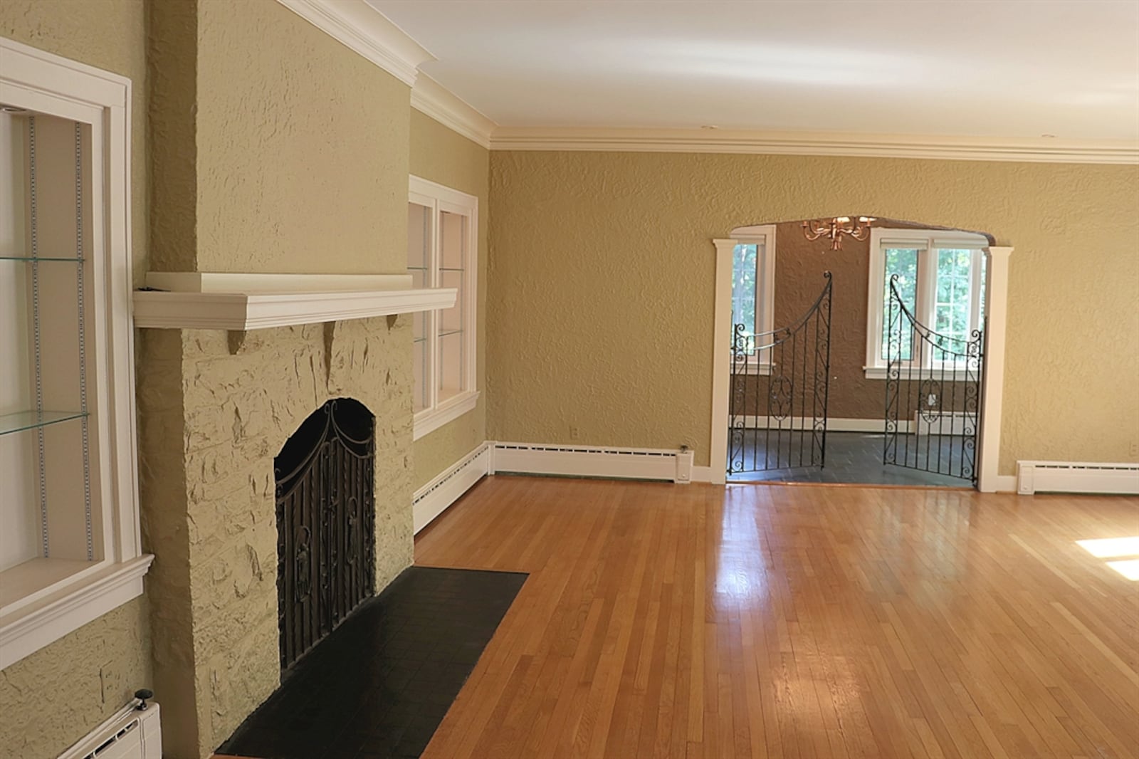 Wrought-iron gates open from the living room into an adjoining sunroom or study. 