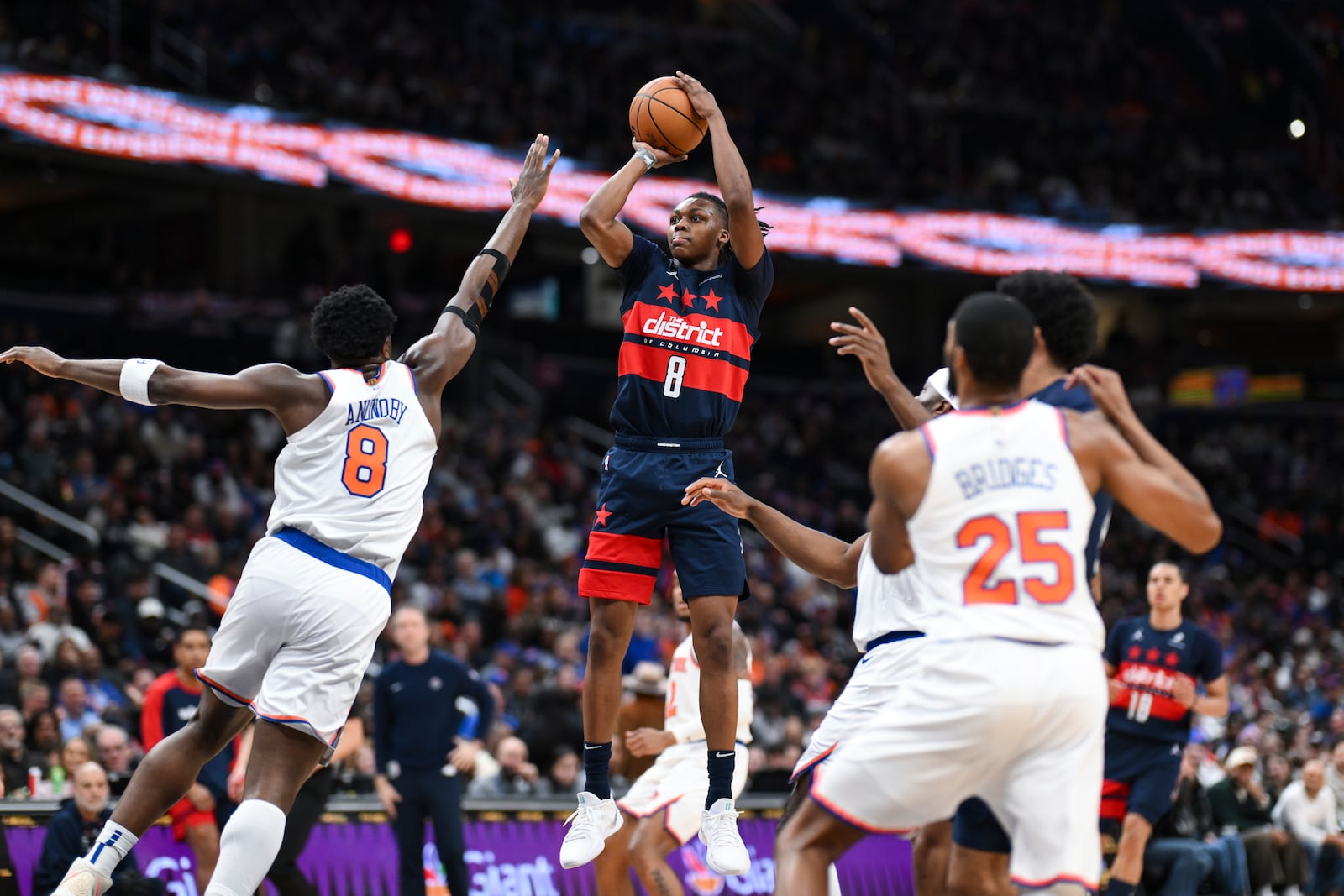 Washington Wizards guard Carlton Carrington (8) shoots the ball as New York Knicks forward OG Anunoby (8) defends during the first half of an NBA basketball game, Saturday, Dec. 28, 2024, in Washington. (AP Photo/Terrance Williams)