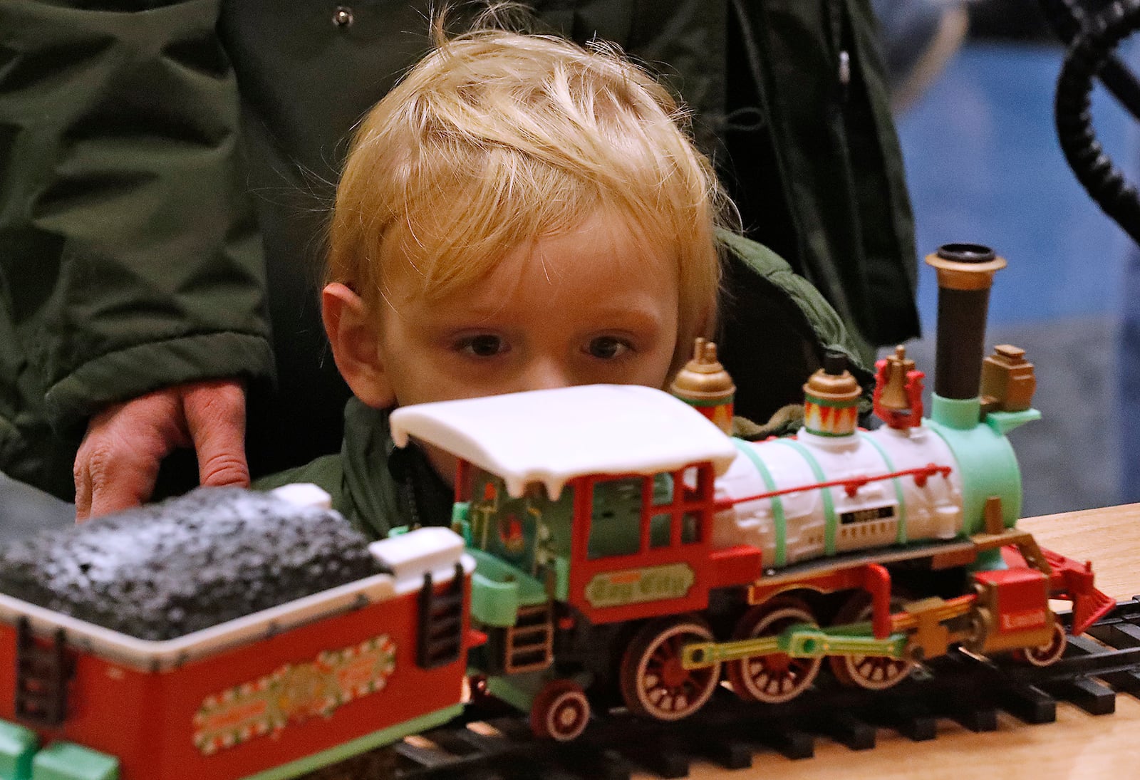 Tucker Hensel, 2, watches a holiday train puff past him in one of the train displays in downtown Springfield Saturday for Holiday in the City. Bill Lackey/Staff