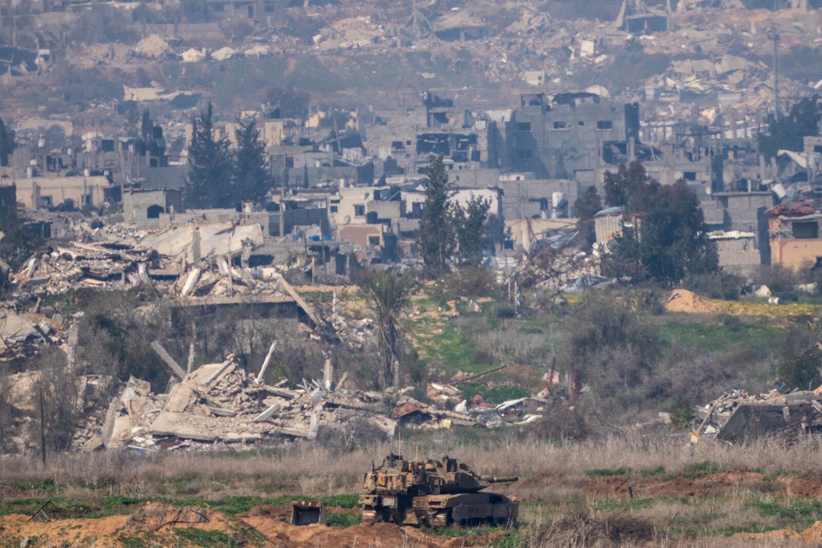 An Israeli tanks sits in a position next to destroyed buildings by Israeli bombardments inside the northern Gaza Strip as seen from southern Israel, Tuesday, Jan. 28, 2025.(AP Photo/Ariel Schalit)