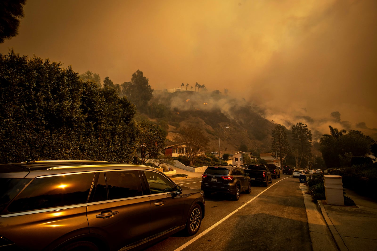 A line of vehicles crowds the road as residents flee from the Palisades Fire in the Pacific Palisades neighborhood of Los Angeles, Tuesday, Jan. 7, 2025. (AP Photo/Ethan Swope)