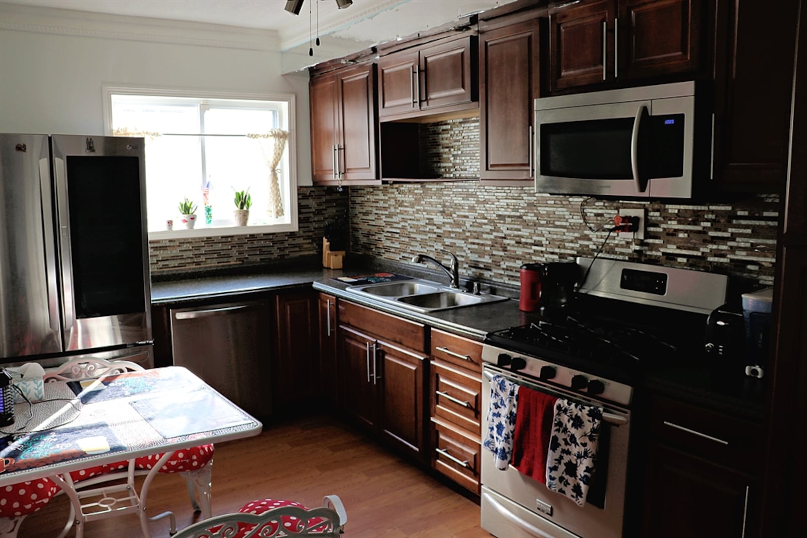 The kitchen has been updated with wood-laminate flooring and stainless-steel appliances. 