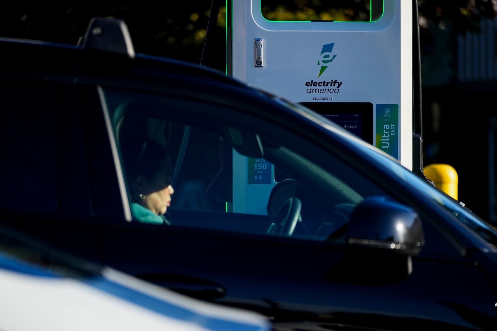 FILE - A driver waits in their car while charging an electric vehicle at an Electrify America station, Oct. 9, 2024, in Seattle. (AP Photo/Lindsey Wasson, File)