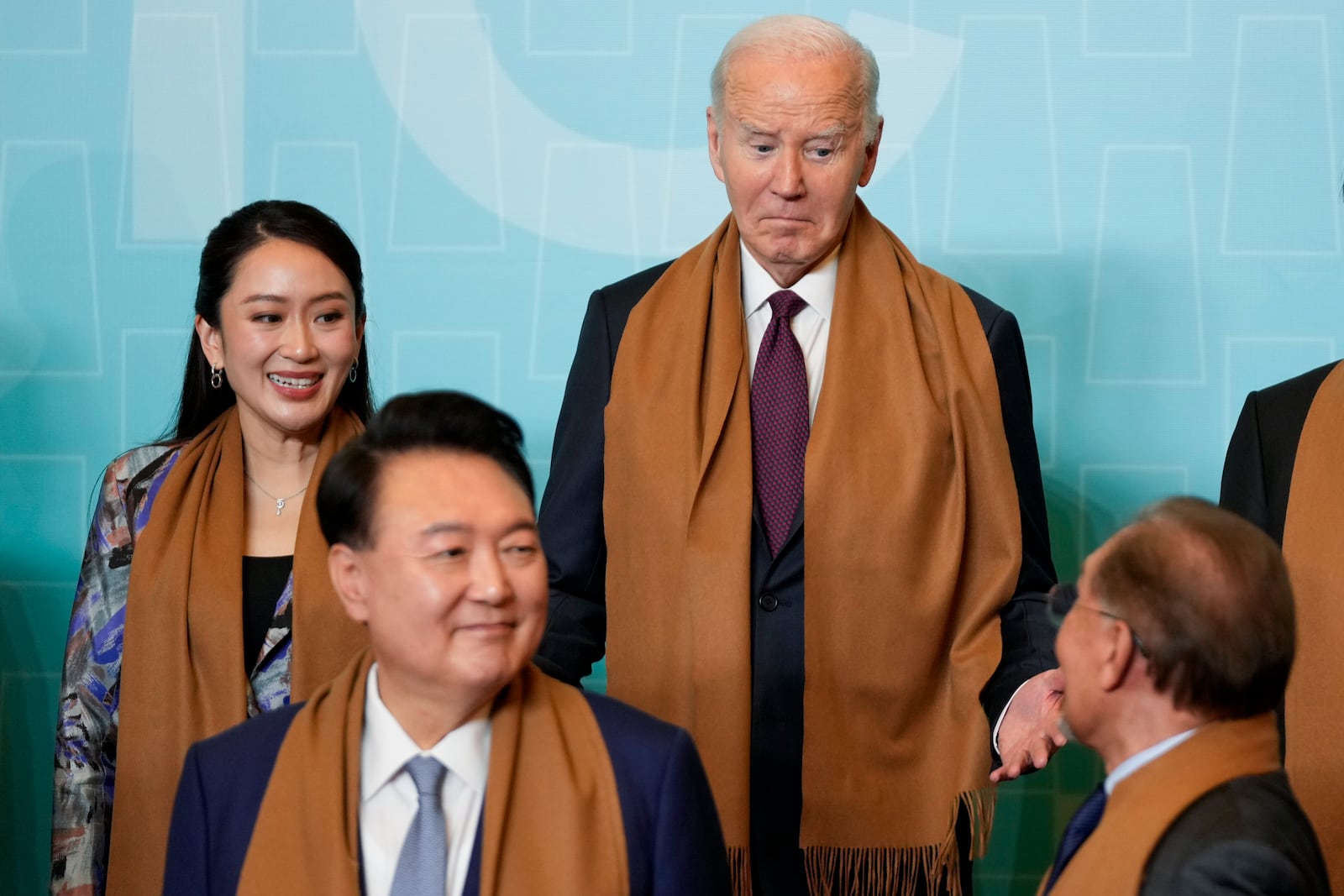 President Joe Biden talks with Malaysia's Prime Minister Anwar Ibrahim flanked by Thailand's Prime Minister Paetongtarn Shinawatra, left, and South Korea's President Yoon Suk Yeol, front left, as they gather for the leaders' group photo during the Asia-Pacific Economic Cooperation (APEC) summit, in Lima, Peru, Saturday, Nov. 16, 2024. (AP Photo/Fernando Vergara)