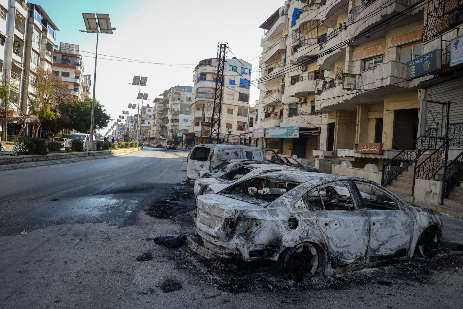 Burnt cars remain in the middle of a street following the recent wave of violence between Syrian security forces and gunmen loyal to former President Bashar Assad, as well as subsequent sectarian attacks, in the town of Jableh, Syria's coastal region, Monday, March 10, 2025. (AP Photo/Omar Albam)