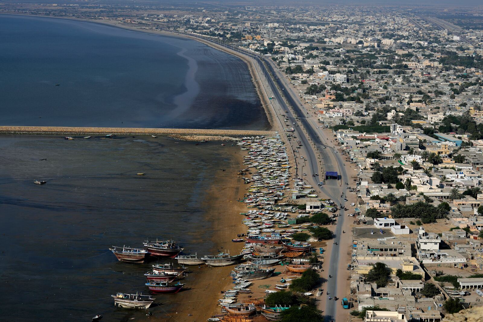 Fishers' boats are docked along the beach next to a new built highway in Gwadar, Pakistan, Tuesday, Jan. 14, 2025. (AP Photo/Anjum Naveed)