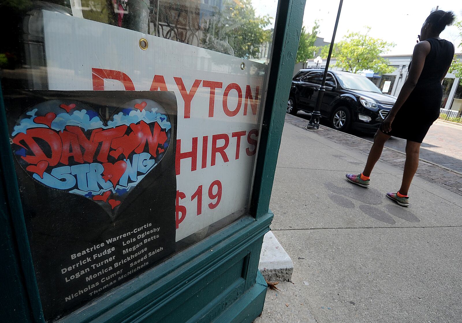 One of the original Dayton Stong posters hangs in the window of Eclectic Essential in the Oregon District. Friday Aug. 4, 2023 will mark the 4th anniversity of the mass shooting. MARSHALL GORBY\STAFF