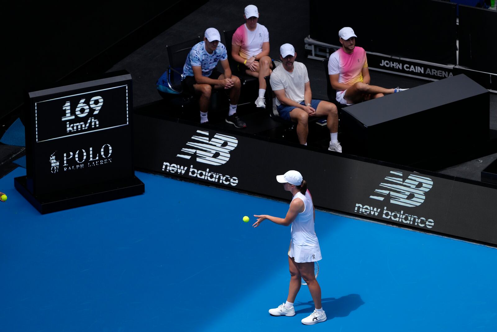 Iga Swiatek of Poland walks past her coaches as she prepares to serve to Katerina Siniakova of the Czech Republic during their first round match at the Australian Open tennis championship in Melbourne, Australia, Monday, Jan. 13, 2025. (AP Photo/Ng Han Guan)