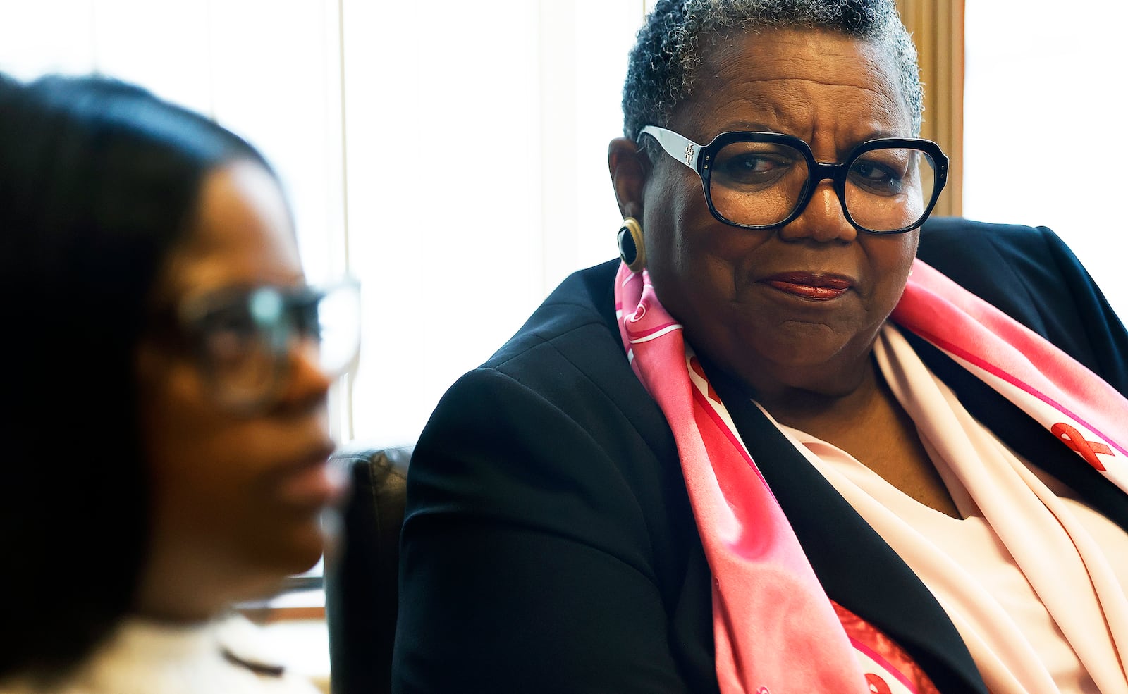 Marva Hughes, a breast cancer survivor, listens as her daughter, Kelly Hughes, talks about going through her own breast cancer diagnosis and treatment not long after watching her mother go through it. They were both treated by the same care team at Miami Valley Hospital North. MARSHALL GORBY\STAFF