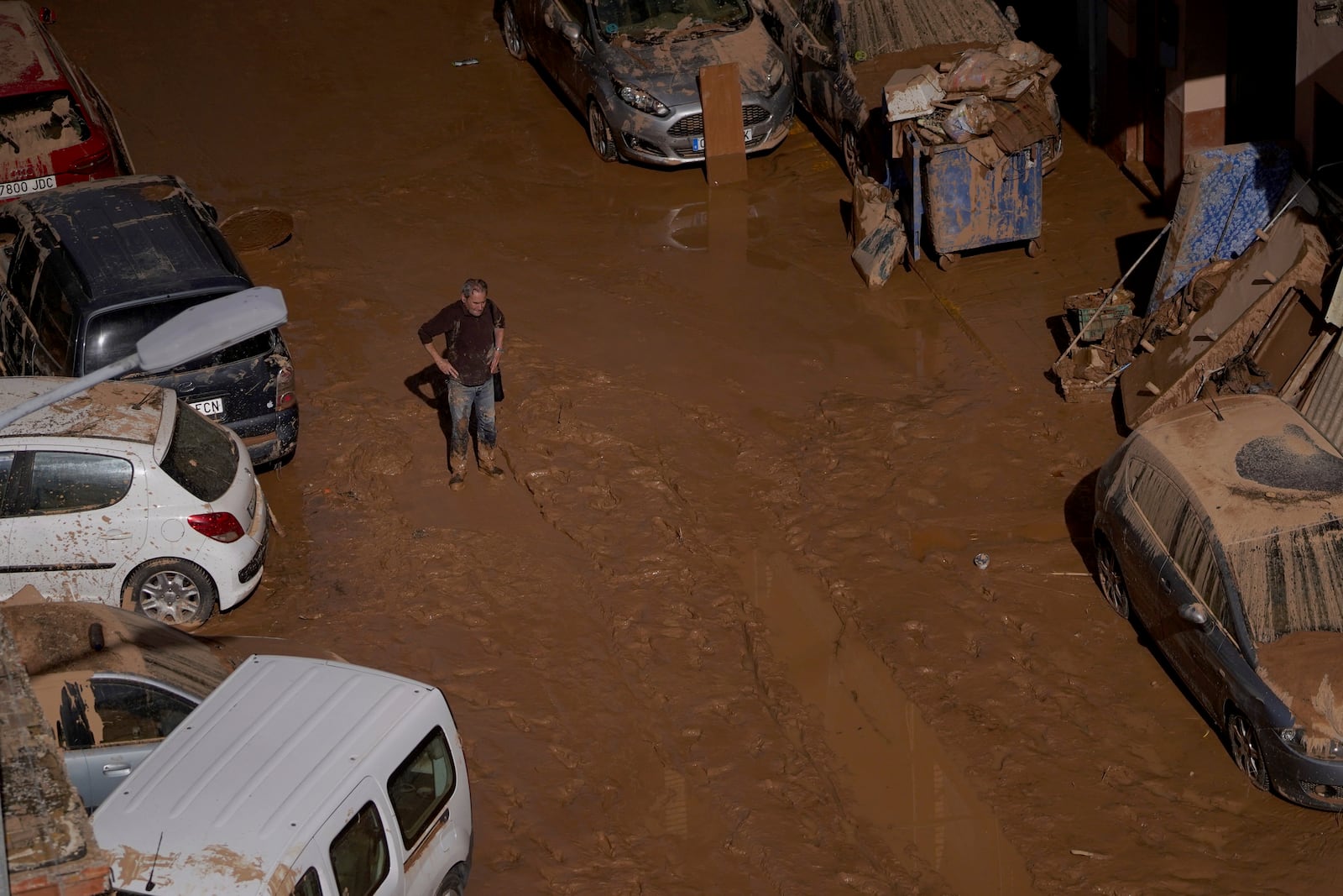 A man stands next to houses affected by floods in Valencia, Spain, Thursday, Oct. 31, 2024. (AP Photo/Alberto Saiz)