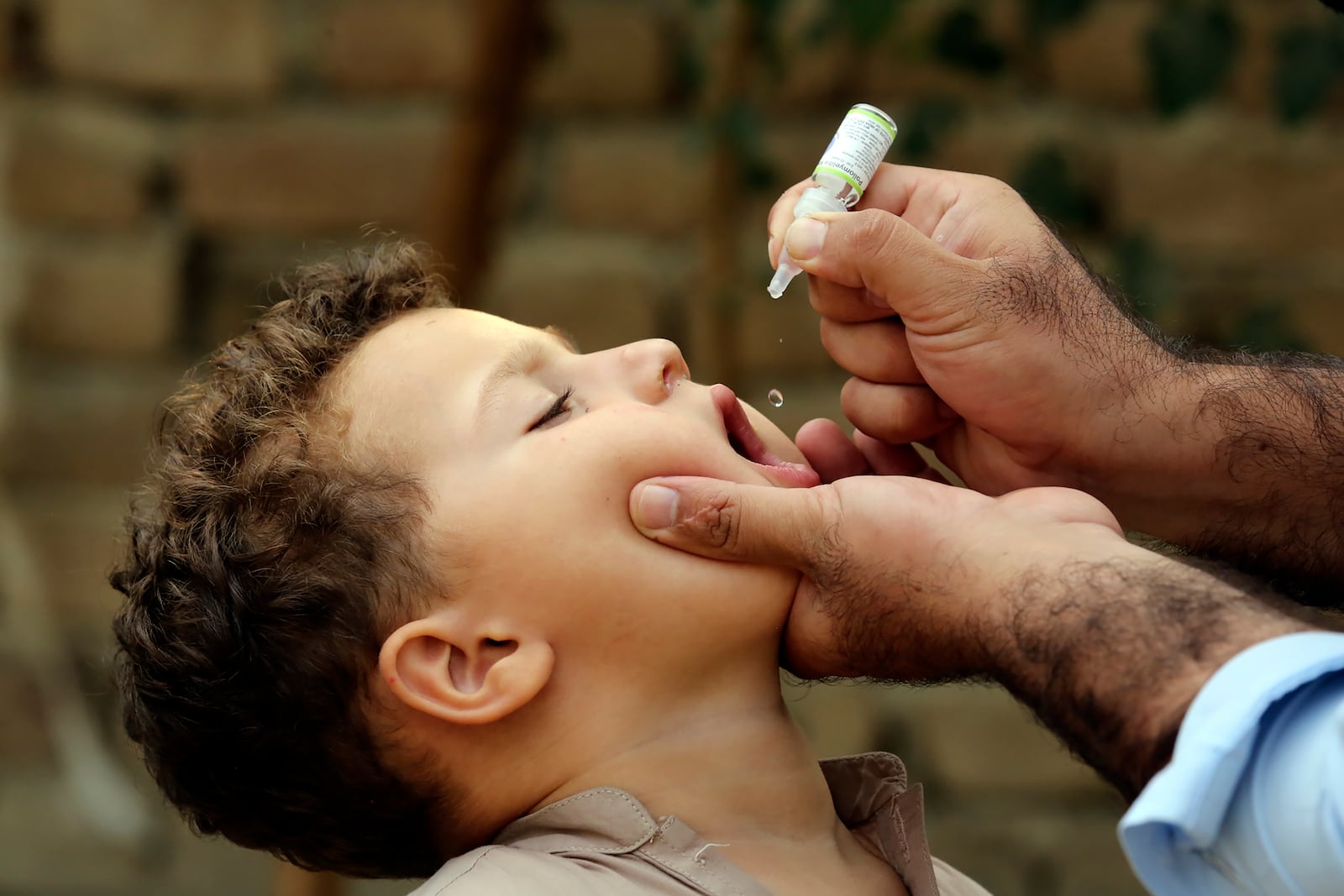 A health worker administers a polio vaccine to a child at a neighborhood of Jalalabad, east of Kabul, Afghanistan, Tuesday, Oct. 29, 2024. (AP Photo/Shafiullah Kakar)