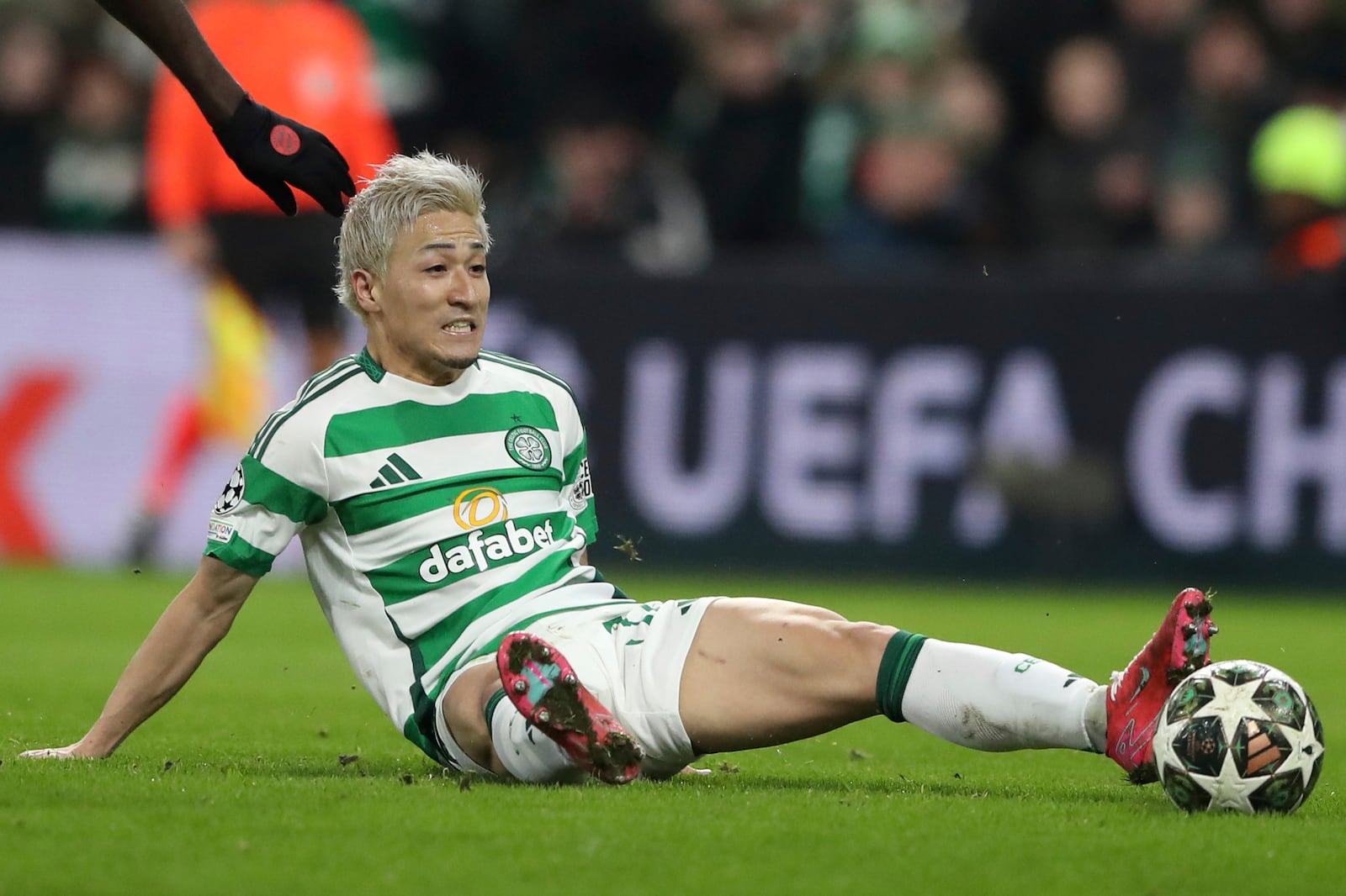 Celtic's Daizen Maeda sits on the ground during the Champions League play off first leg soccer match between Celtic Glasgow and Bayern Munich at the Celtic Park Stadium in Glasgow, Scotland, Wednesday, Feb. 12, 2025. (AP Photo/Scott Heppell)