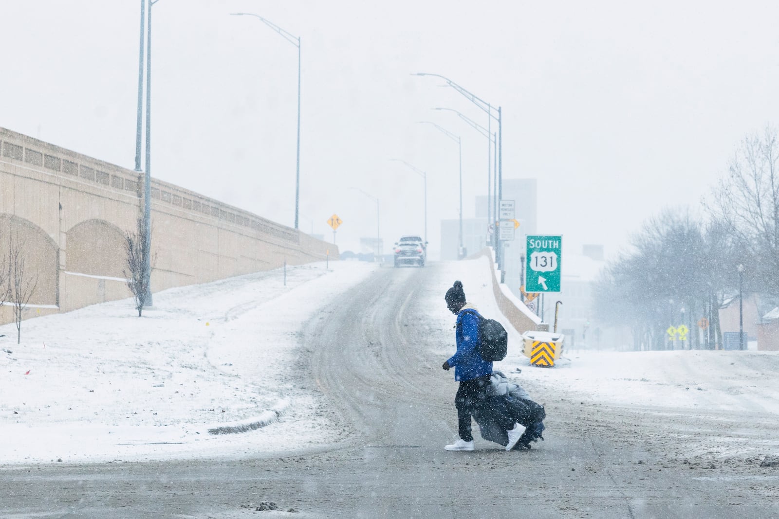 A person drags their luggage through the snow in Grand Rapids, Mich., Friday, Jan. 10, 2025. (Joel Bissell/Kalamazoo Gazette via AP)