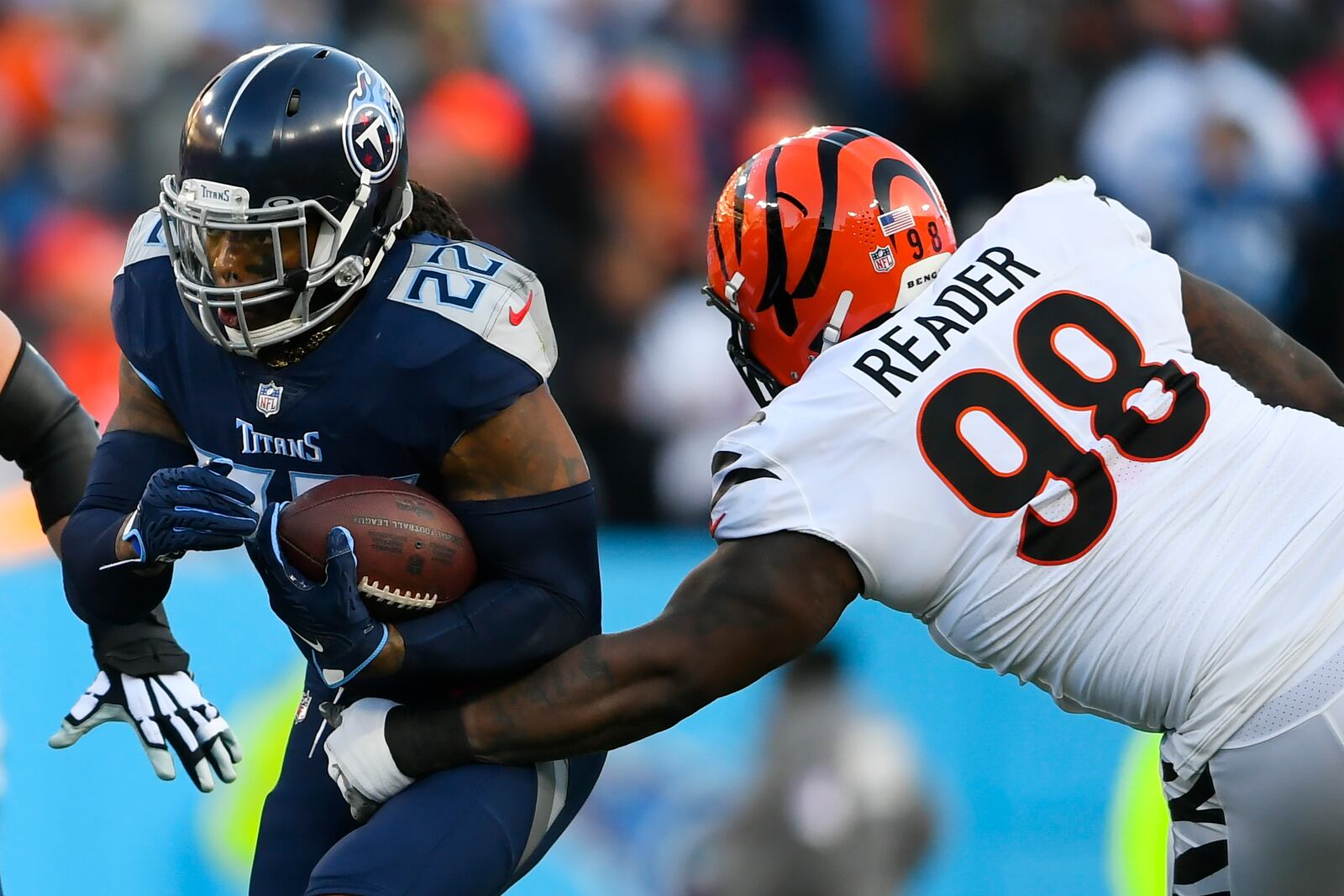 Tennessee Titans running back Derrick Henry (22) runs near Cincinnati Bengals nose tackle D.J. Reader (98) during the first half of an NFL divisional round playoff football game, Saturday, Jan. 22, 2022, in Nashville, Tenn. (AP Photo/John Amis)