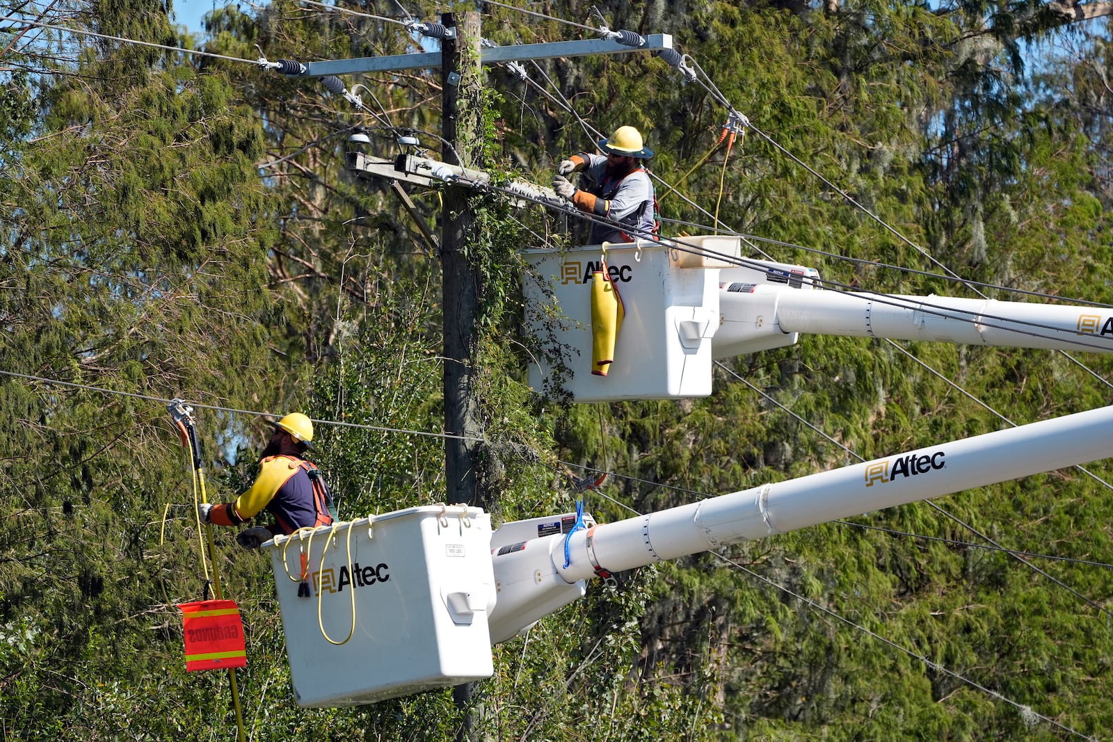 Pike Corporation linemen from North Caolina, repair power pole damaged by Hurricane Milton Monday, Oct. 14, 2024, in Lithia, Fla. (AP Photo/Chris O'Meara)