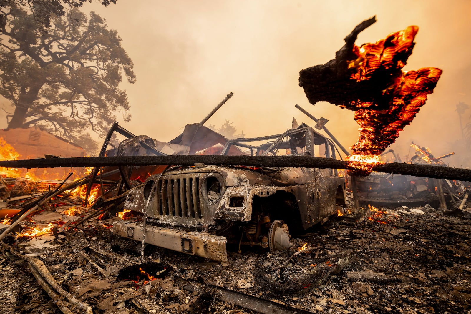 A burned vehicle sits among a destroyed home in the Mountain fire, Wednesday, Nov. 6, 2024, near Camarillo, Calif. (AP Photo/Ethan Swope)