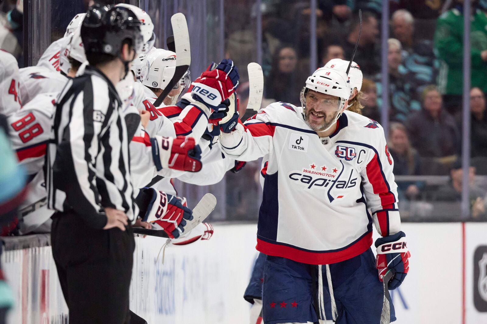 Washington Capitals left wing Alex Ovechkin (8) is congratulated after scoring against the Seattle Kraken during the third period of an NHL hockey game, Thursday, Jan. 23, 2025, in Seattle. (AP Photo/John Froschauer)