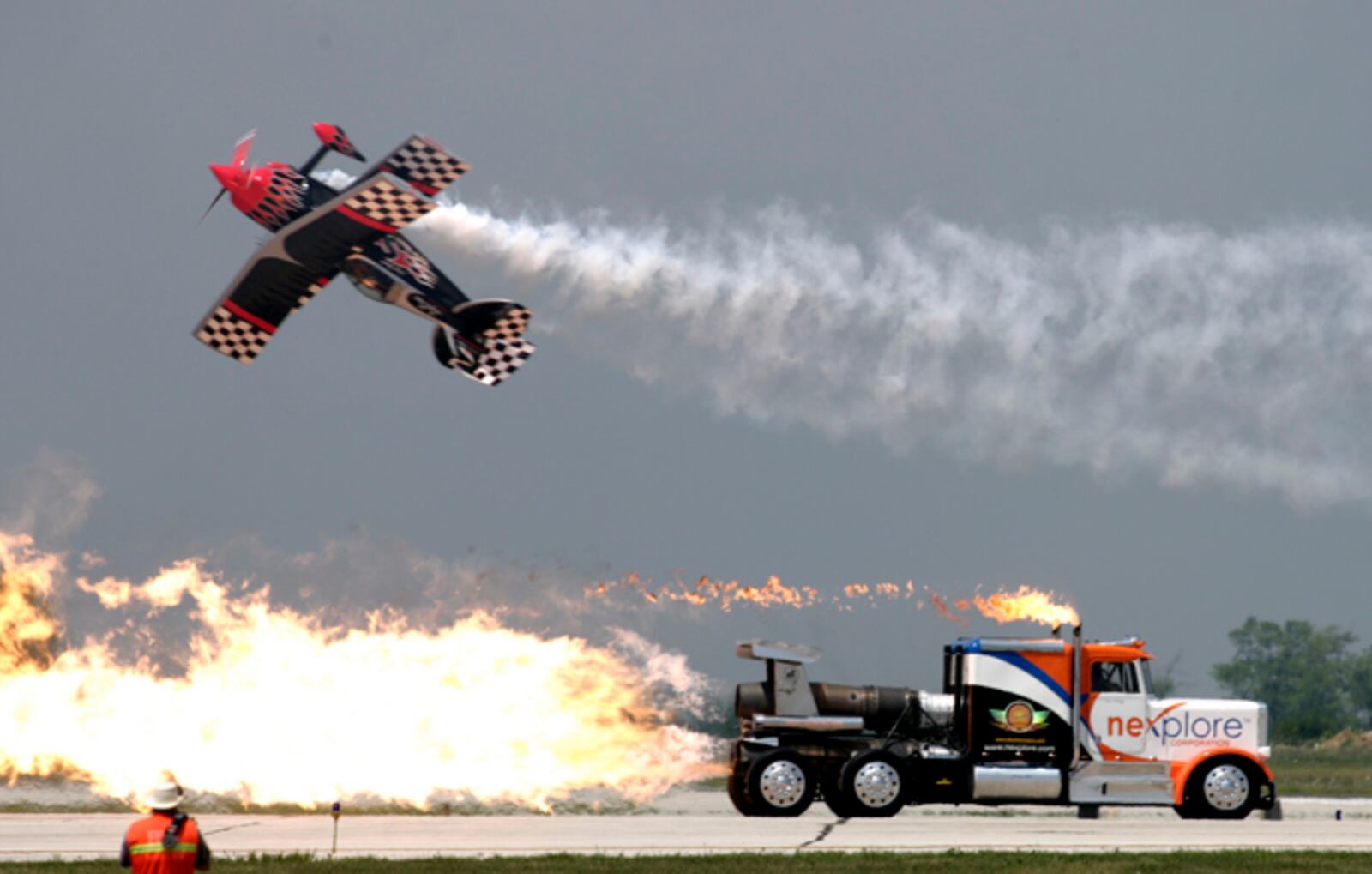 Skip Stewart zips past Kent Shockley and the Shockwave Truck at the Vectren Dayton Air Show in 2007. It's fun to watch the spectators crowd the fence when the jet trucks or School Time Bus take the runway.