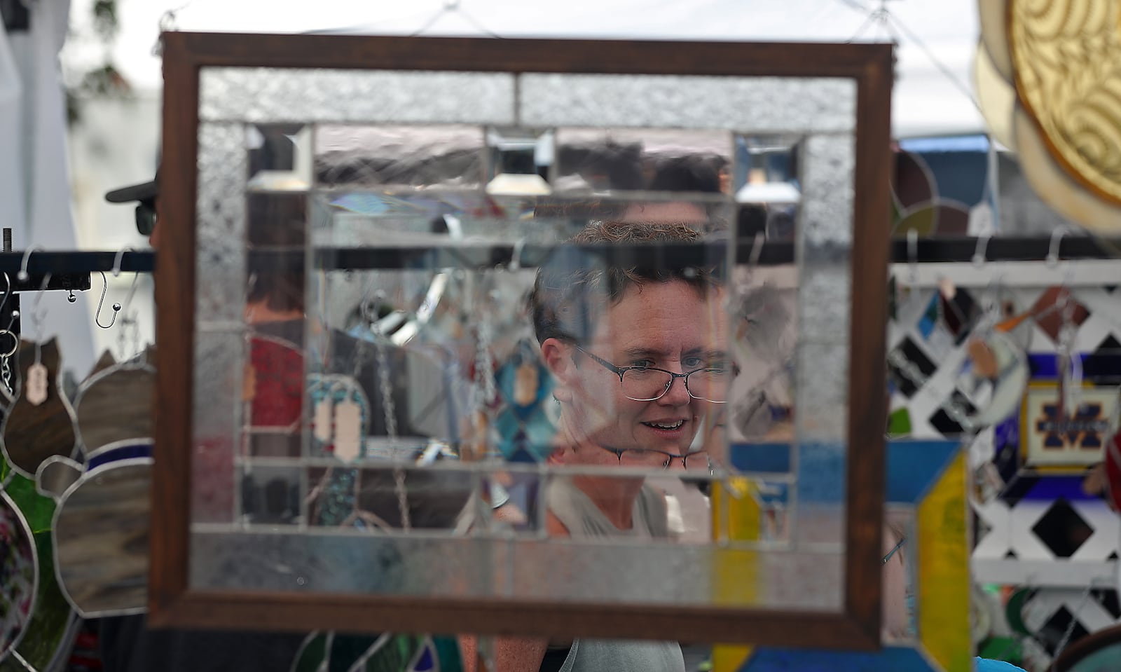 A woman shops at a booth selling stained glass items at the Enon Apple Butter Festival. BILL LACKEY/STAFF