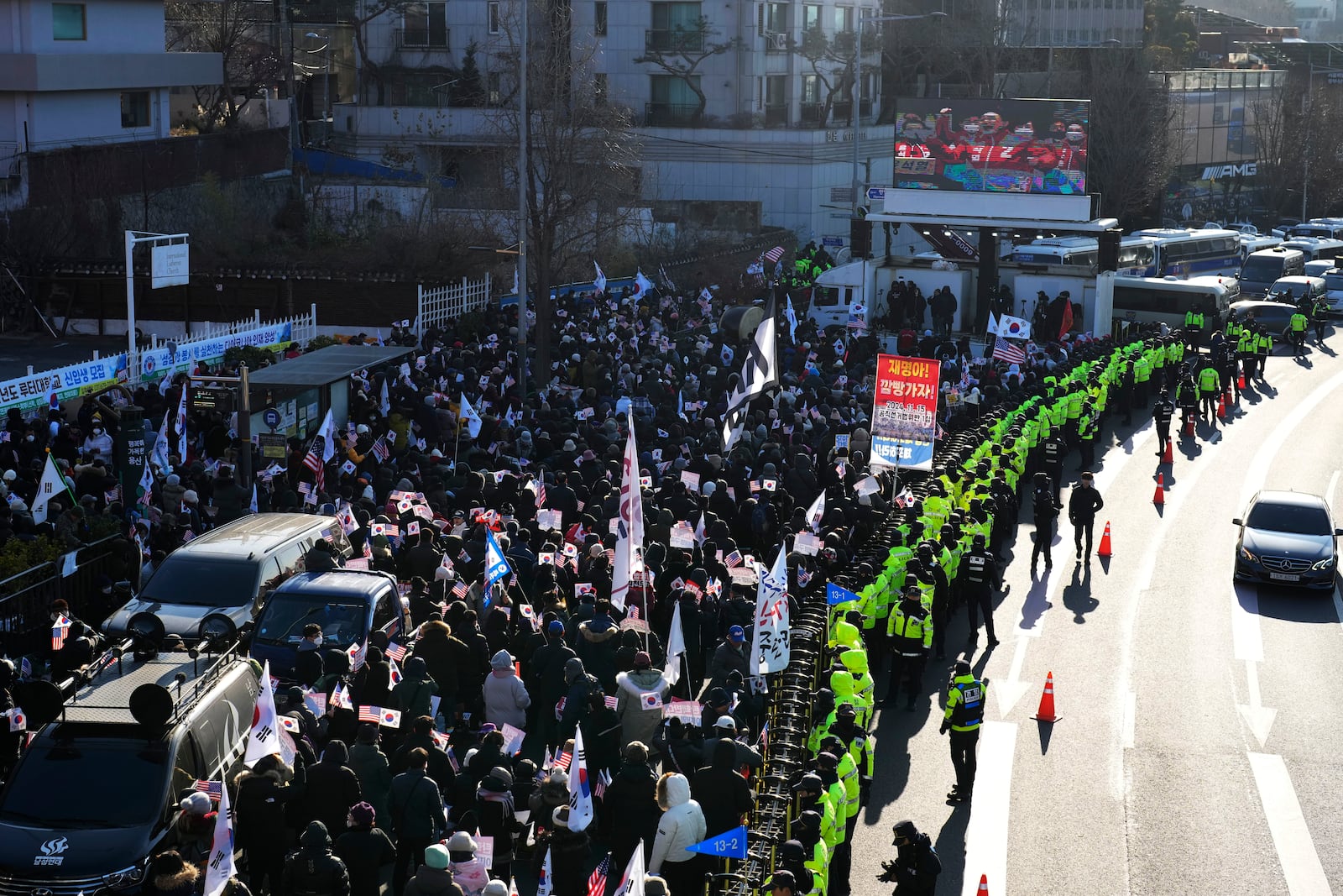 Supporters of impeached South Korean President Yoon Suk Yeol stage a rally to oppose a court having issued a warrant to detain Yoon, as police offices stand guard near the presidential residence in Seoul, South Korea, Friday, Jan. 3, 2025. (AP Photo/Lee Jin-man)