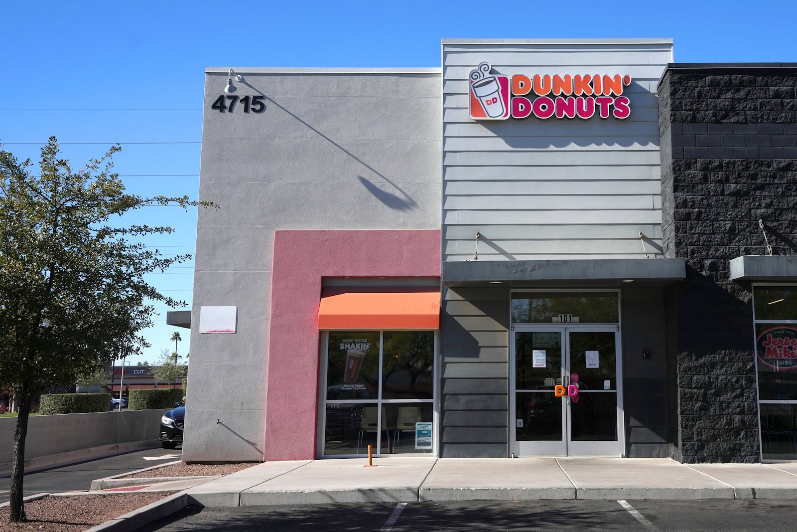 Signs on the doors of a Dunkin' Donuts restaurant explains that customers will find limited doughnut selections for sale Friday, Jan. 10, 2025, in Tempe, Ariz. (AP Photo/Ross D. Franklin)