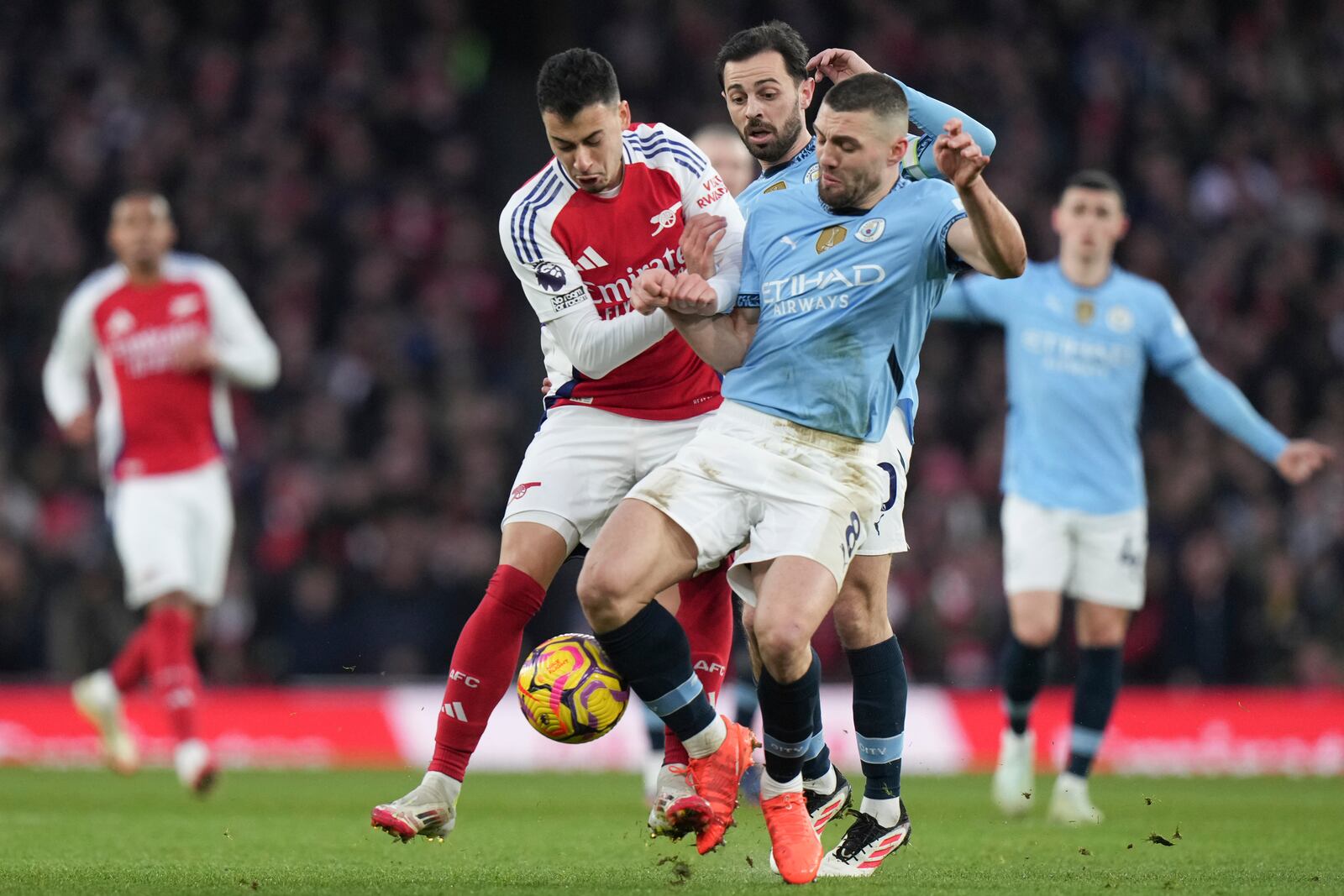 Manchester City's Mateo Kovacic, right, and Arsenal's Gabriel Martinelli fight for the ball during the English Premier League soccer match between Arsenal and Manchester City at the Emirates stadium in London, Sunday, Feb. 2, 2025. (AP Photo/Alastair Grant)