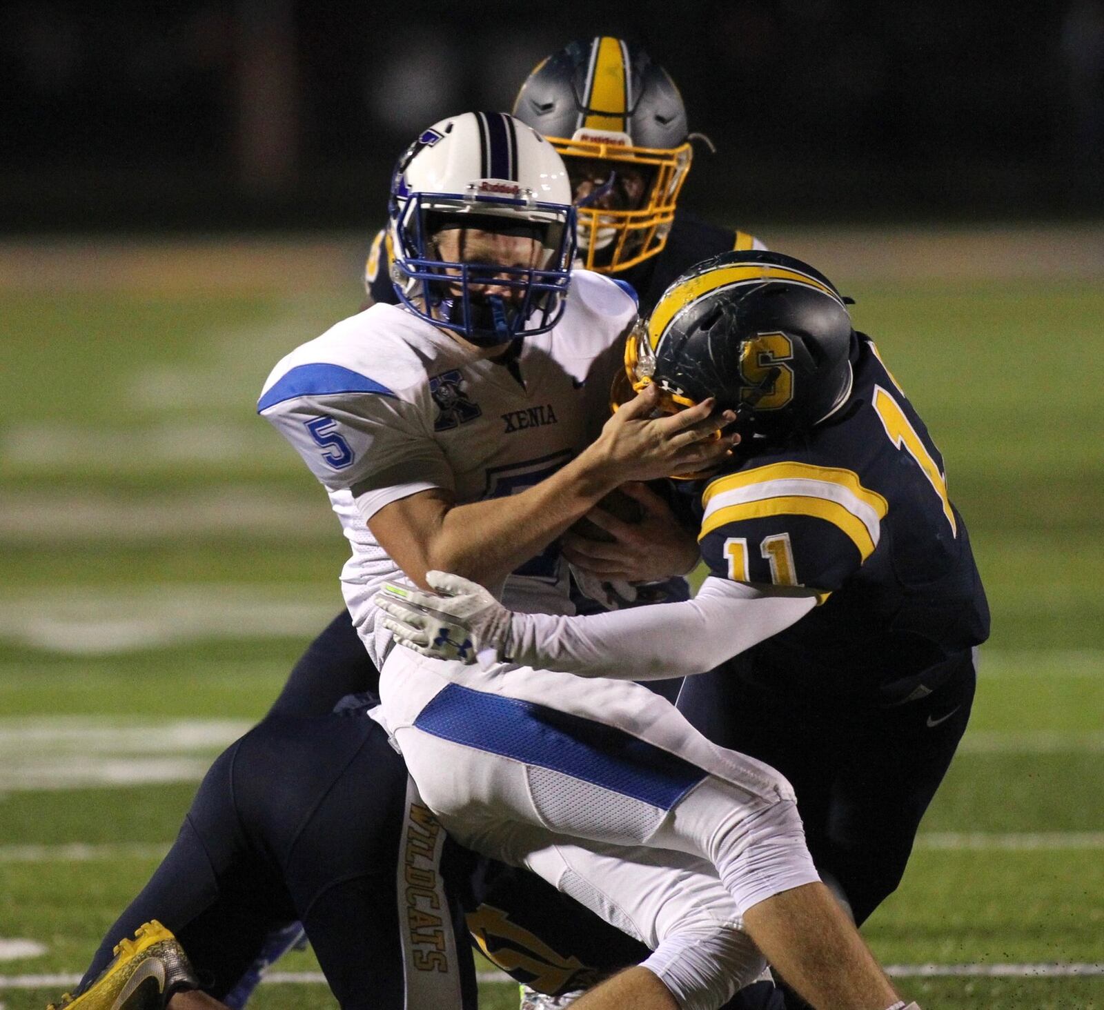 Springfield’s Xzerious Stinnett tackles Xenia’s Christian Severt on Friday, Sept. 28, 2018, at Evans Stadium in Springfield. David Jablonski/Staff